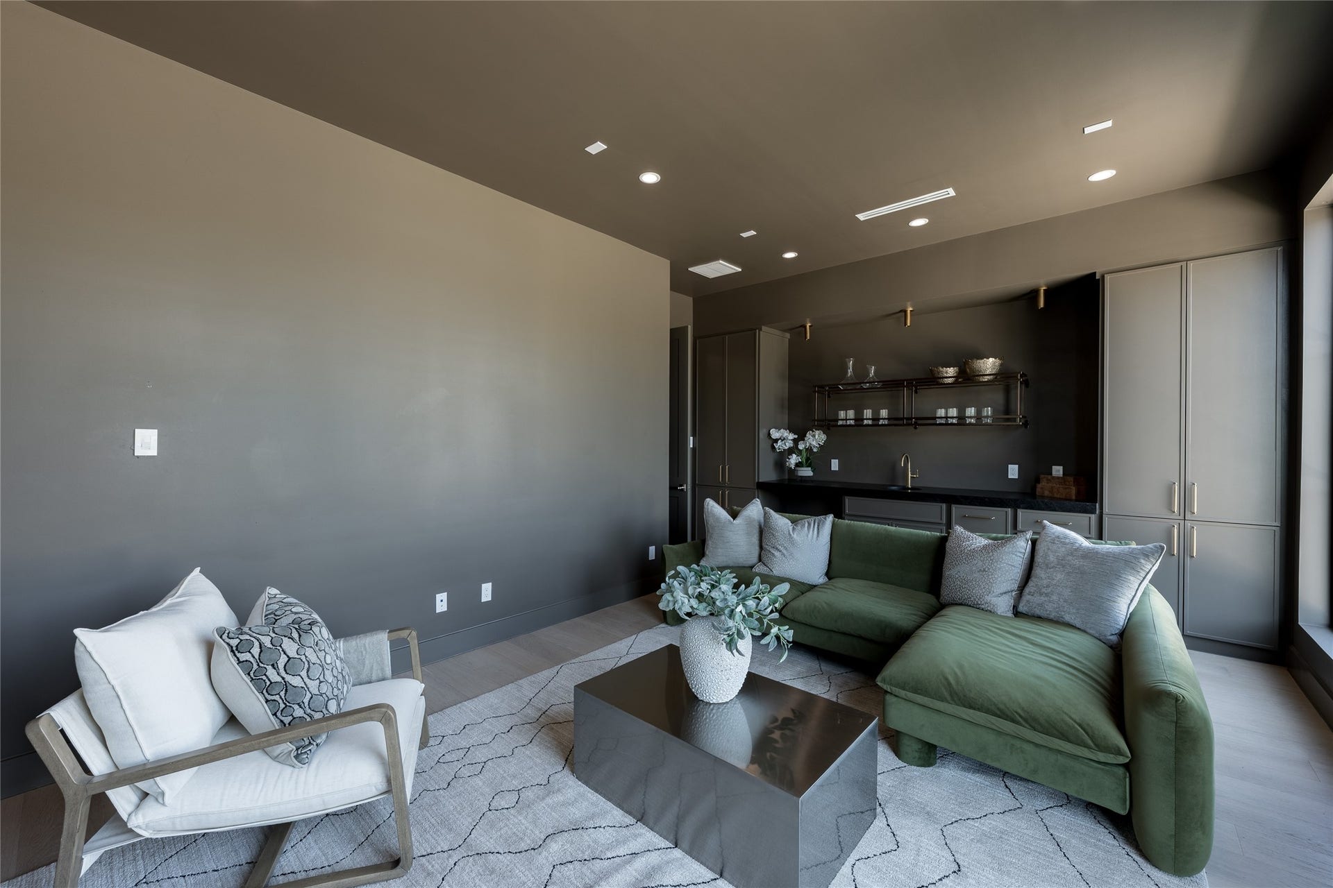 1109 Voight Street, Houston, TX 77009 A second perspective of the media room reveals a thoughtfully appointed lounge, where rich, moody tones meet relaxed comfort. Custom cabinetry, an integrated beverage station, and warm metallic accents create a sophisticated setting for entertaining or unwinding.