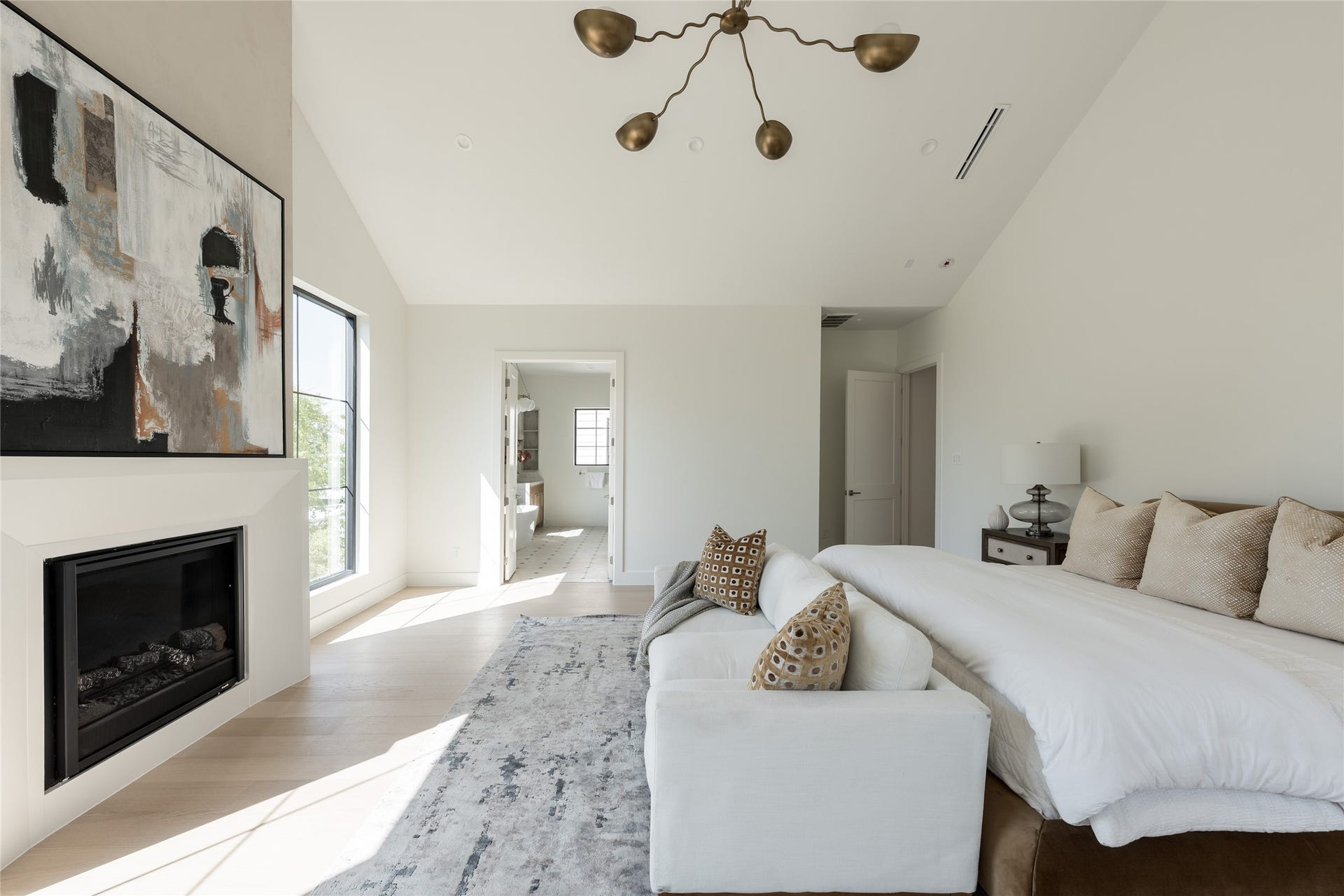 1109 Voight Street, Houston, TX 77009 An intimate sitting area and sleek fireplace bring warmth and dimension to the primary bedroom. Just beyond, the primary bath extends the experience with a continuation of the home's refined finishes and considered details.
