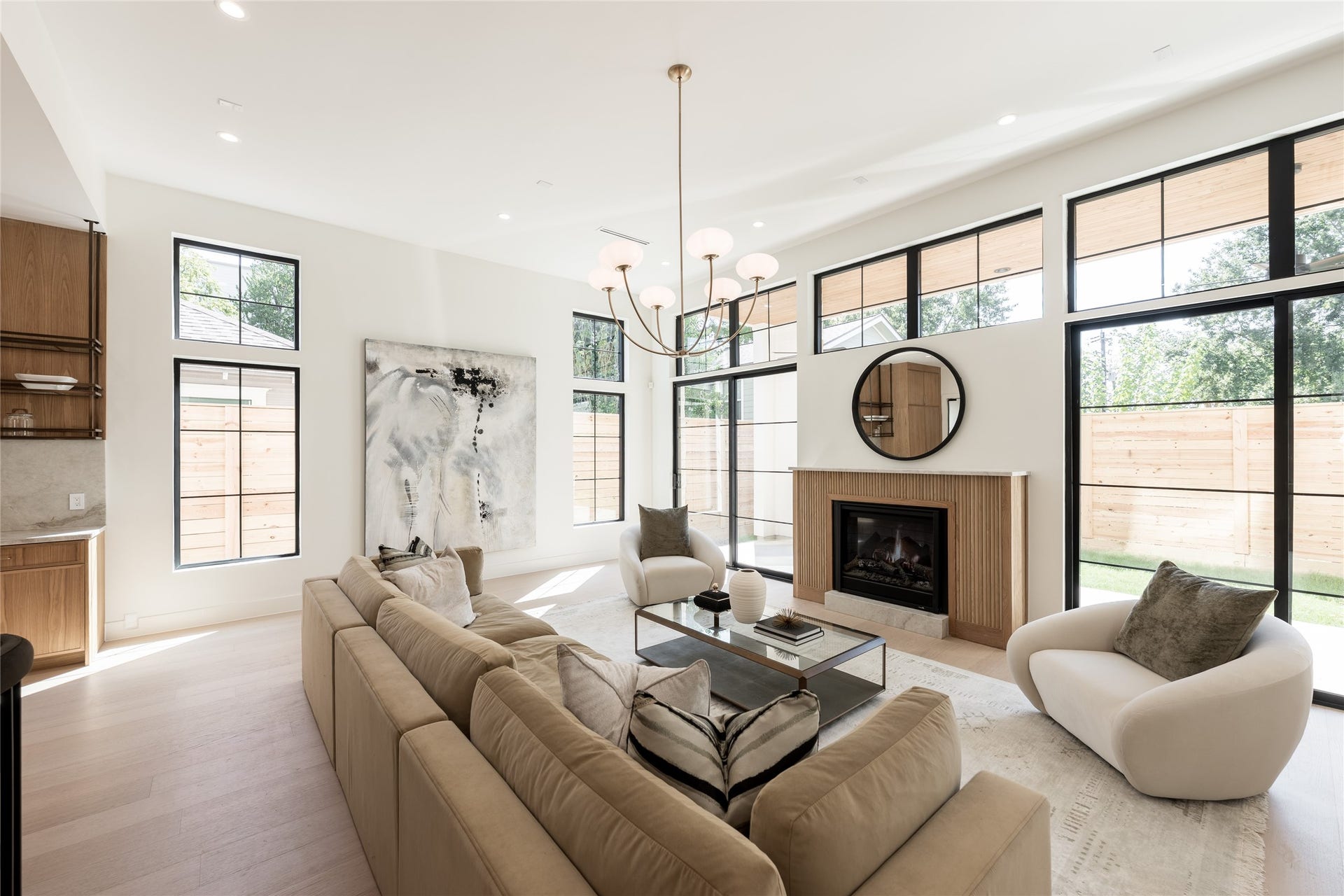 1109 Voight Street, Houston, TX 77009 The great room balances dramatic scale with warmth, pairing 12 foot ceilings and a fluted fireplace with walls of grid windows that bring natural light deep into the space.