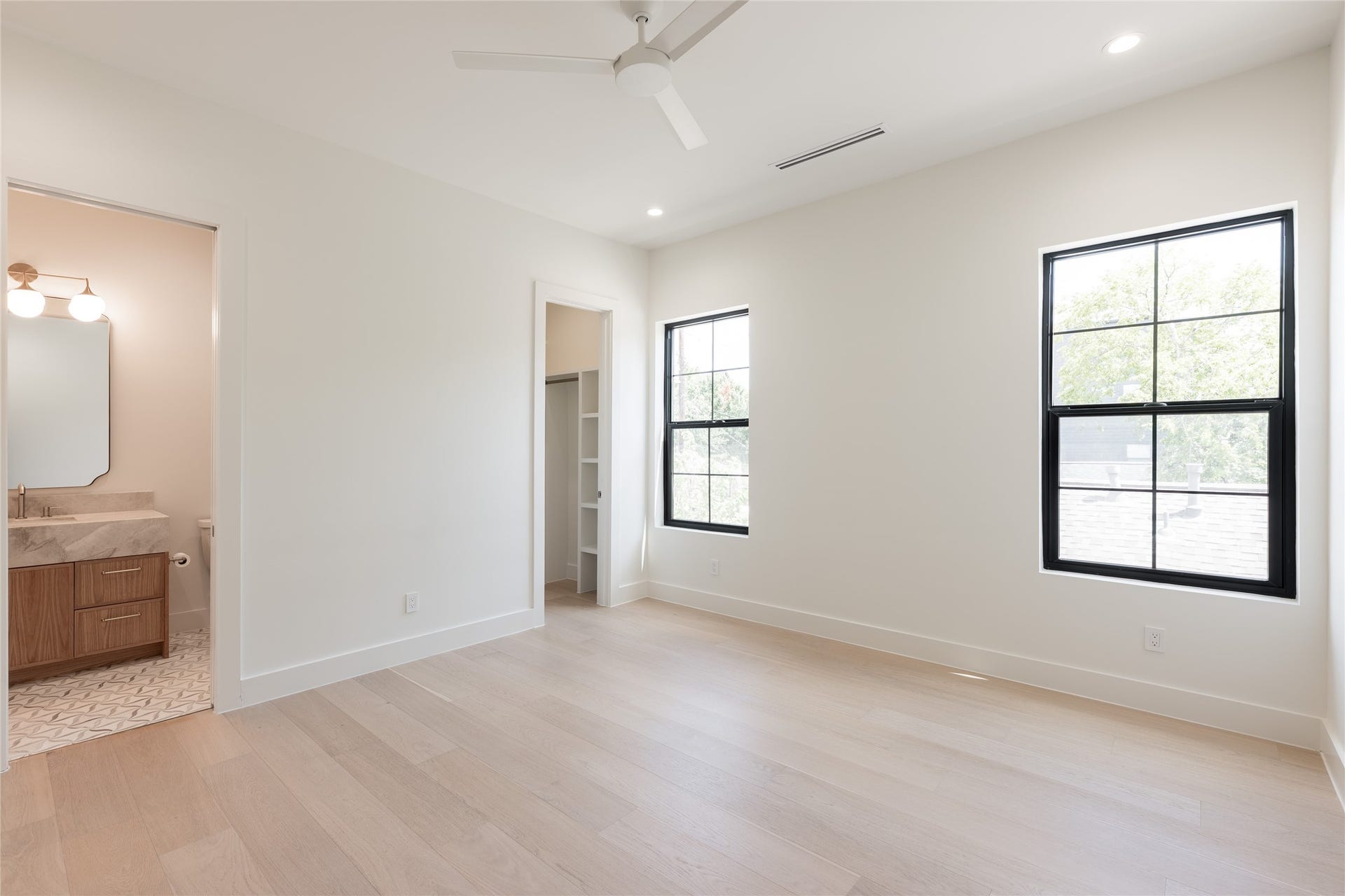 1109 Voight Street, Houston, TX 77009 The secondary bedroom is generously scaled and filled with natural light, with direct access to its private ensuite bath creating a comfortable retreat for family or guests.