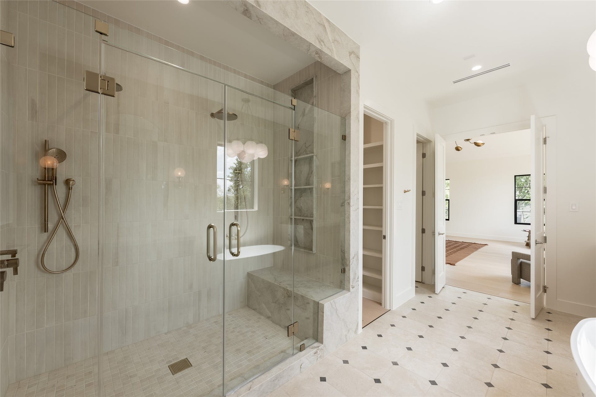 1109 Voight Street, Houston, TX 77009 The oversized glass enclosed shower brings another layer of luxury to the primary bath, with full height designer tile and a built in bench creating a spa like experience at home.