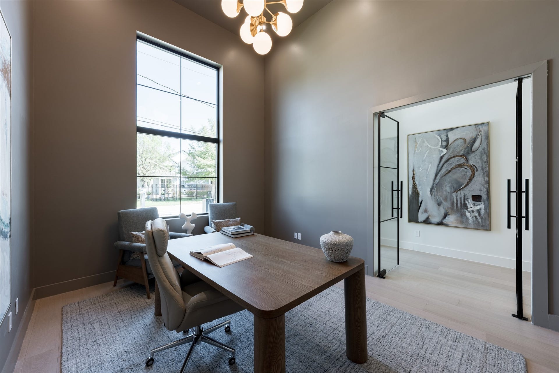 1109 Voight Street, Houston, TX 77009 The private study pairs a dramatic 15 foot ceiling with glass walls that preserve the homes sense of openness, while a concealed bookcase door adds an unexpected layer of privacy.
