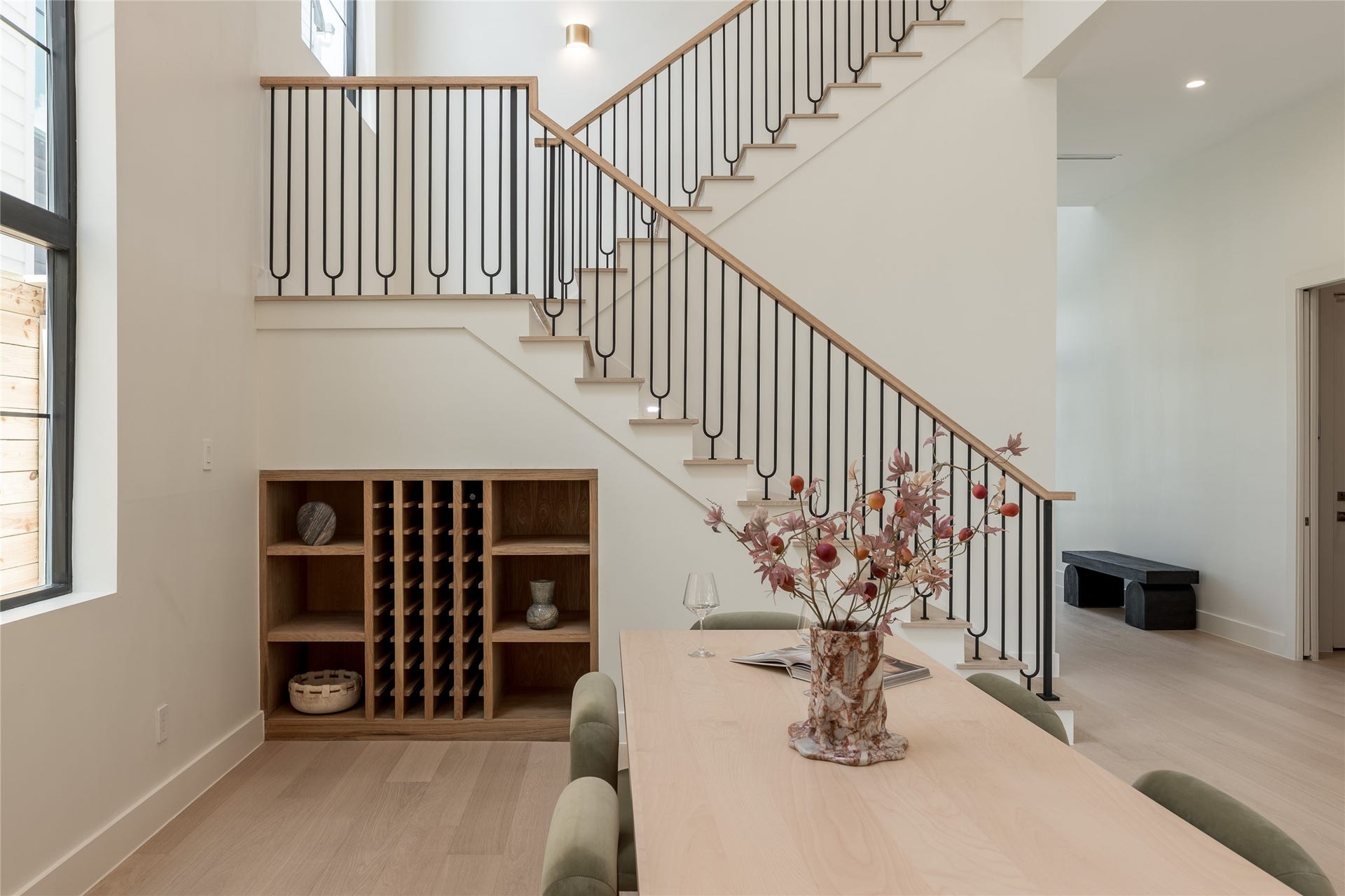 1109 Voight Street, Houston, TX 77009 The custom oak staircase becomes an architectural centerpiece, with its modern railing system rising above the built in wine cove and adding definition to the dining rooms dramatic vertical scale.