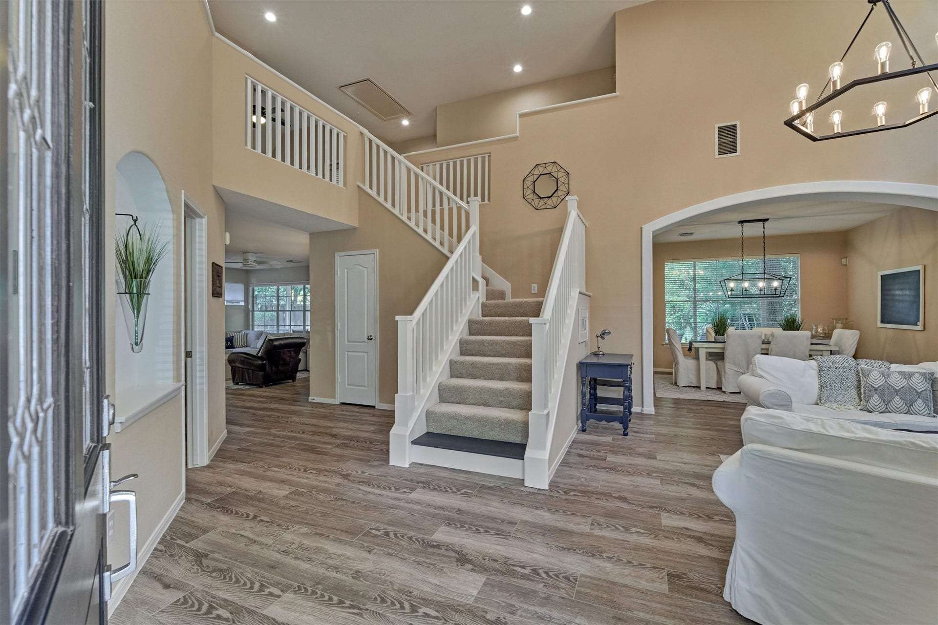 WOW! Step inside to soaring ceilings, beautiful sightlines, and continuous wood-look tile flooring throughout the first-floor living spaces!