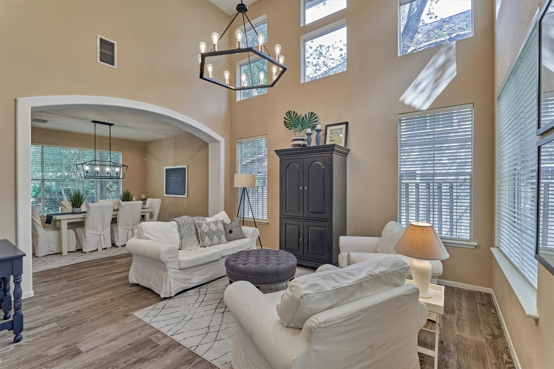 Truly picturesque living room is bathed in natural light, seamlessly connecting to the dining room, entryway, and surrounding living spaces.