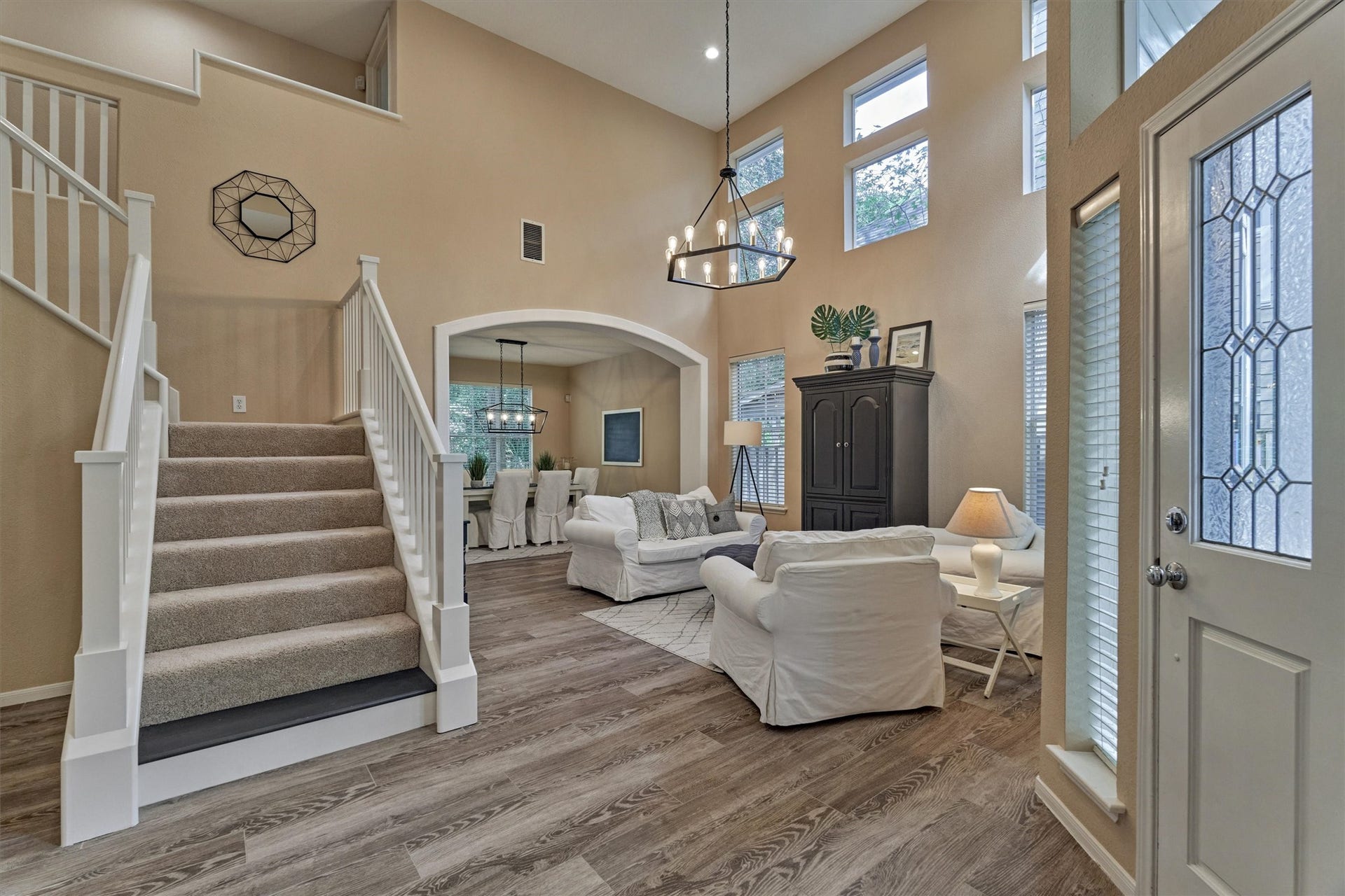 The living room boasts soaring ceilings and a wall of windows that fills the space with abundant natural light.