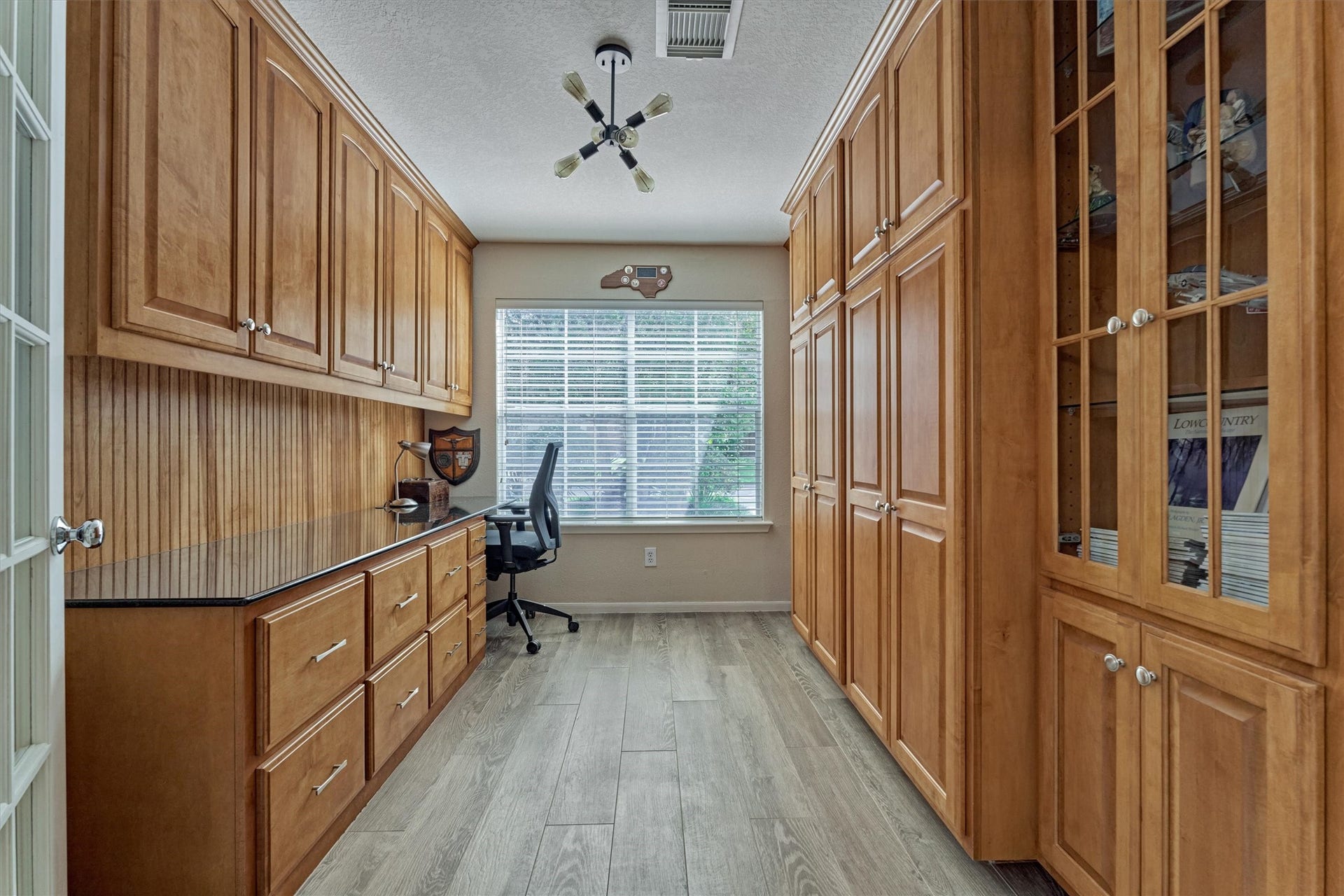 Dedicated home office features custom built-ins, and offers ample storage, plus a functional workspace!