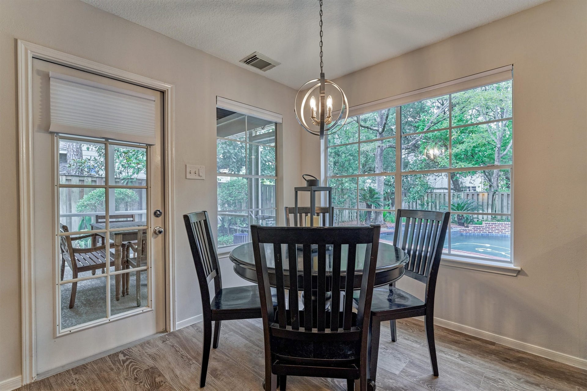Sun-filled breakfast room offers serene views of the sparkling pool and spa with extended dining area on the adjacent, screened-in patio!