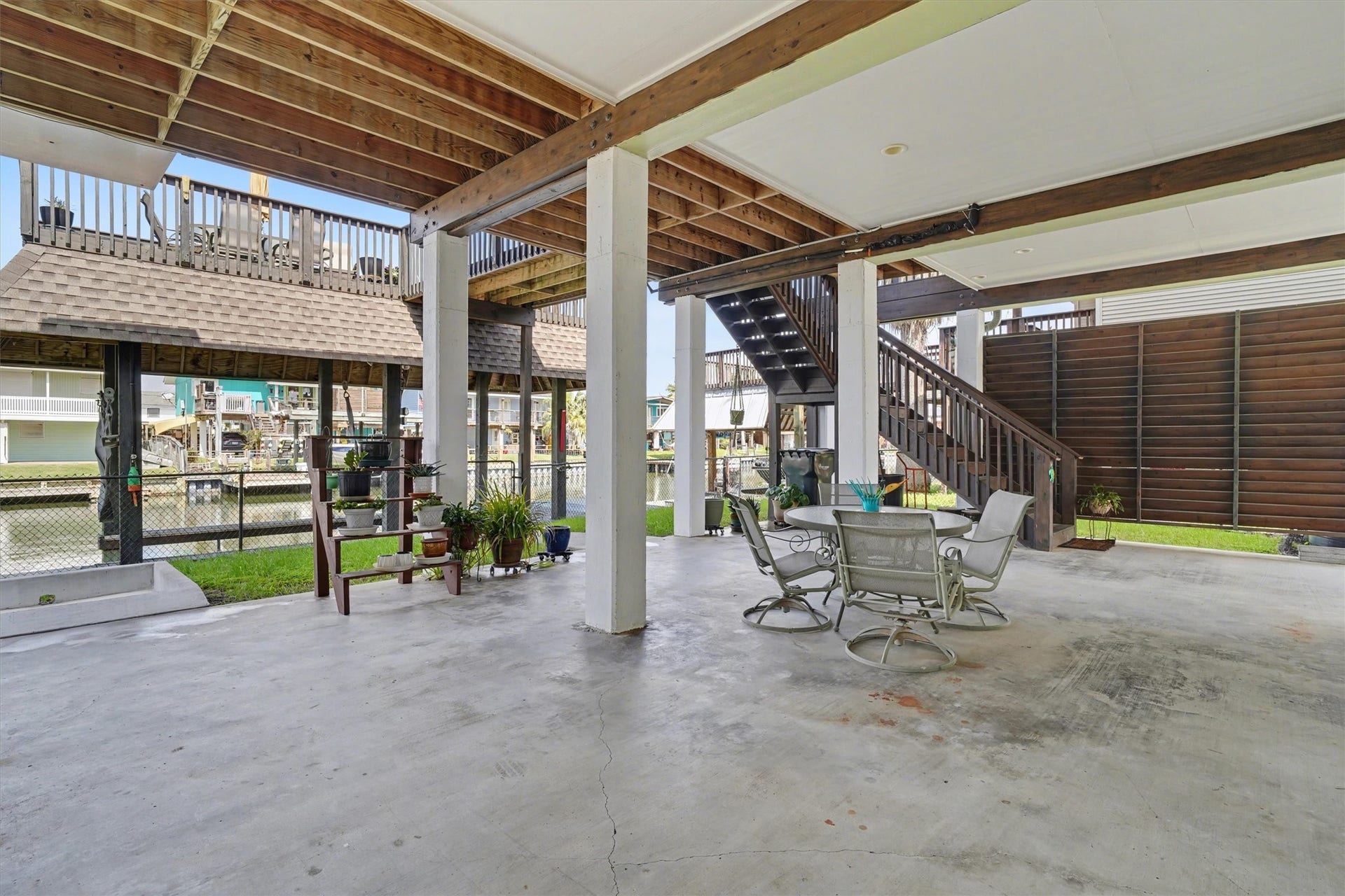 437 Pompano Street, Bayou Vista, TX 77563 Downstairs open area designed as the heart of waterfront living, offering generous space for outdoor dining and a large sectional sofa. Perfect for entertaining, relaxing, and enjoying the coastal breeze, this inviting space captures the essence of life by the water