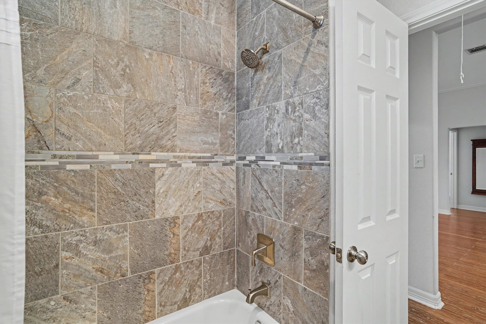 437 Pompano Street, Bayou Vista, TX 77563 The custom tiled shower/tub is perfect for those who want a tub or have small children needing a tub. Notice the detail tile work