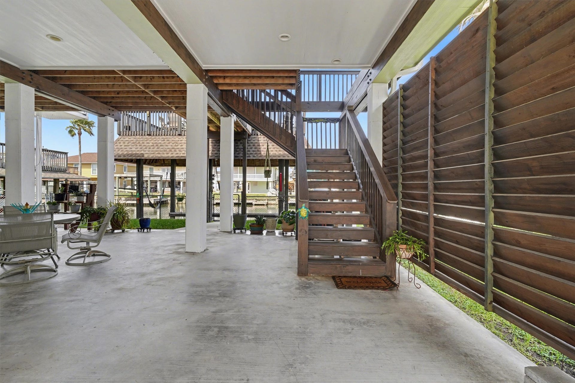 437 Pompano Street, Bayou Vista, TX 77563 Inviting downstairs entertaining area designed for relaxation and gatherings, offering plenty of space for your favorite outdoor furniture. Enjoy the perfect blend of privacy and comfort with stylish side slats that create a cozy retreat while letting in the gentle coastal breezean ideal spot for unwinding or hosting under the open sky