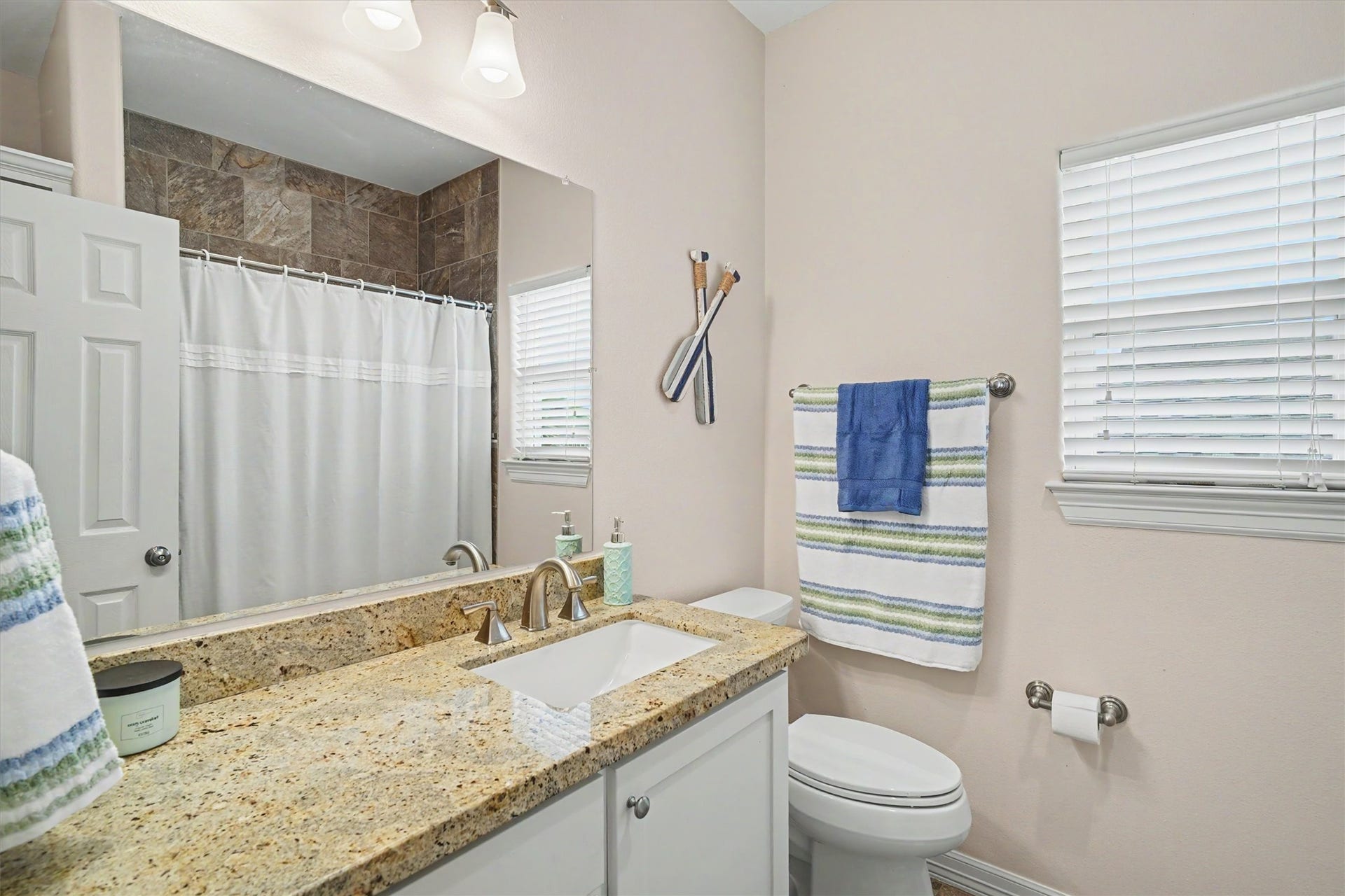 437 Pompano Street, Bayou Vista, TX 77563 The guest bathroom carries the white cabinetry throughout the home. Granite countertops are an extra touch
