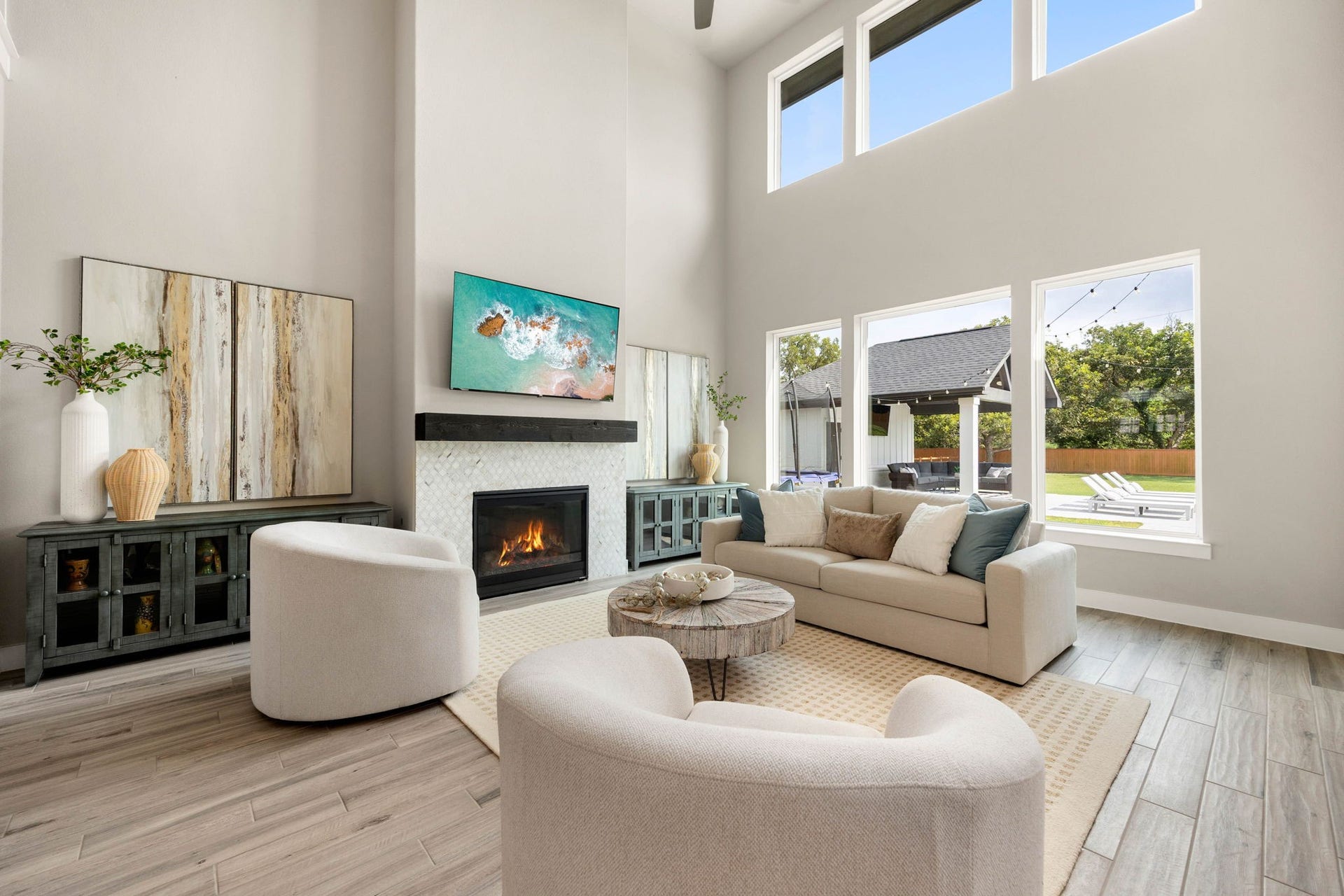 Light-filled family room with soaring ceilings, a cozy fireplace and beautiful backyard views.