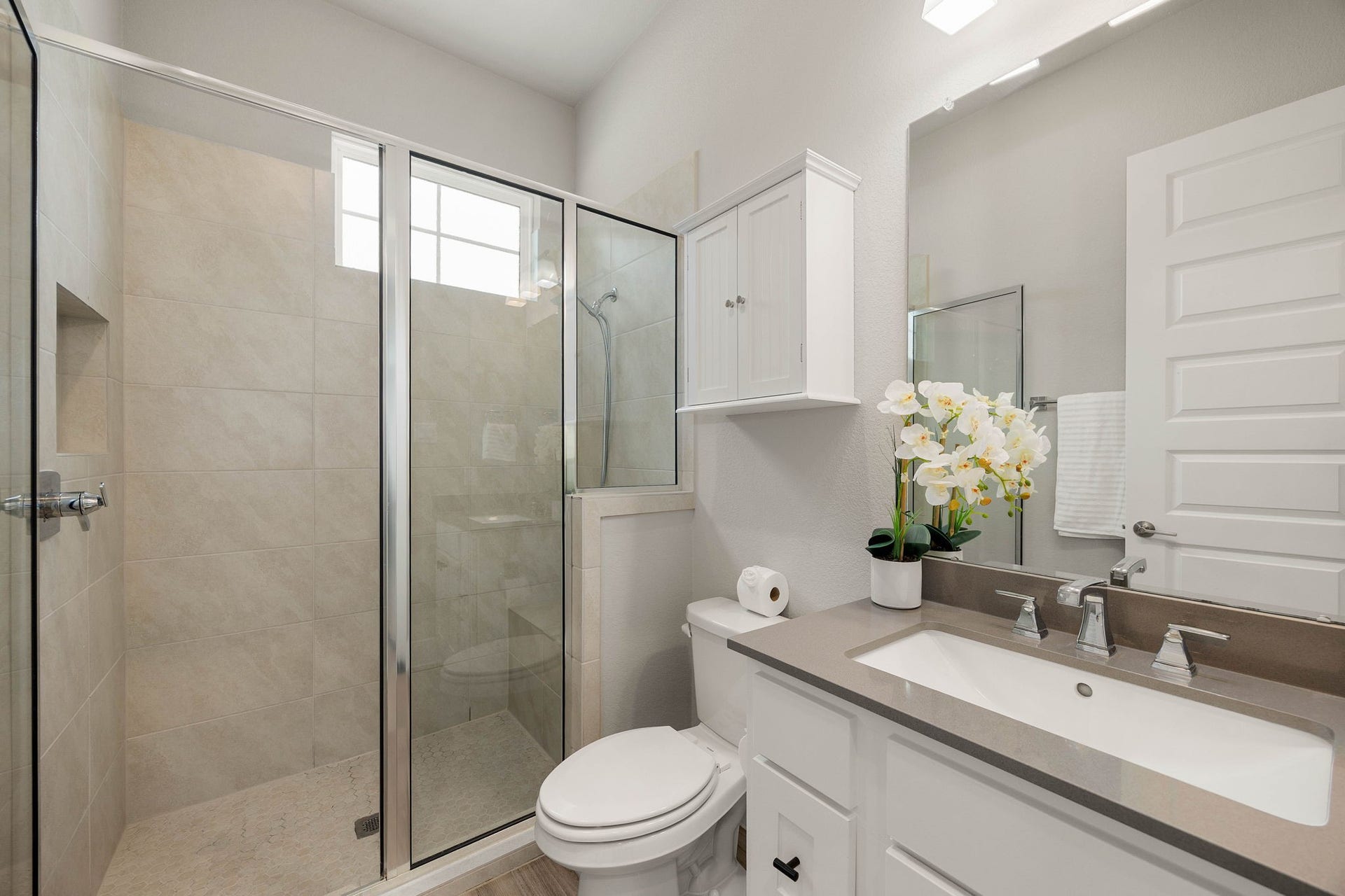 Bright casita bathroom features a large walk-in shower and clean, modern finishes.
