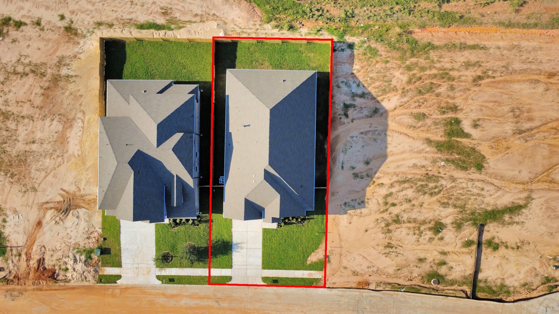 An aerial view of a spacious subdivision lot, highlighting a well-maintained yard and a fully fenced perimeter, offering both privacy and expansive outdoor space.