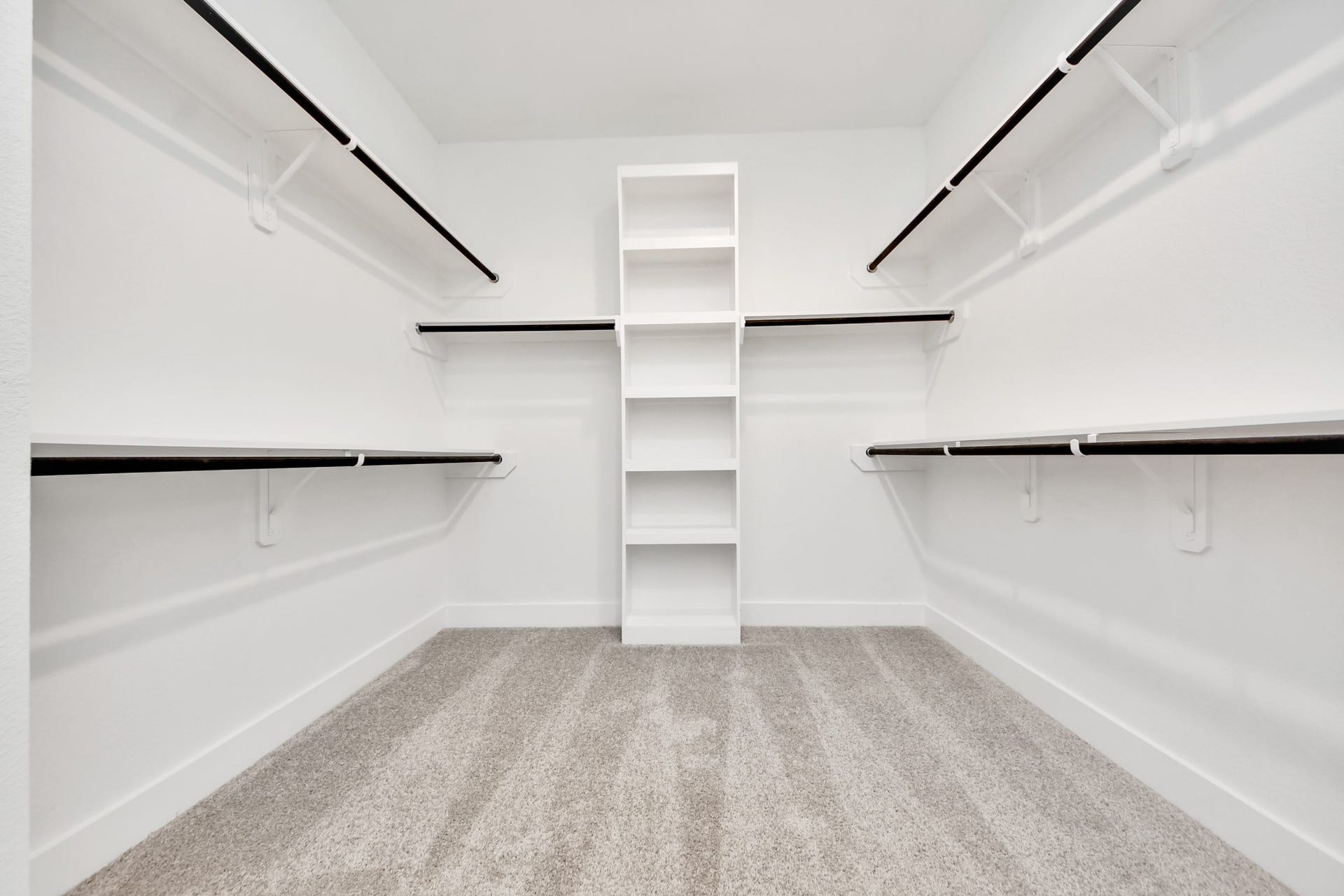 Walk-in closet that epitomizes luxury and practicality. This generously sized space features built-in shelving, offering abundant room for impeccable organization. High ceilings and recessed lighting create a bright and welcoming ambiance.