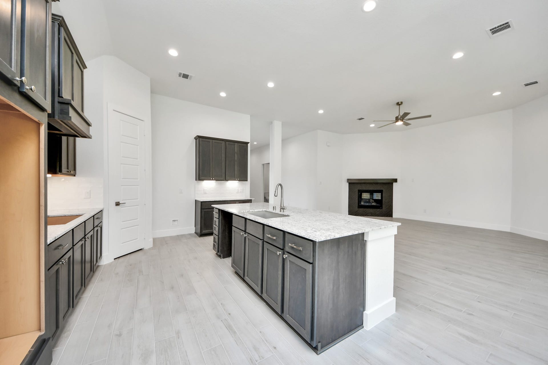 This kitchen is by far any chefs dream! This spacious kitchen features high ceilings, stained wood cabinets, granite countertop, SS appliances, modern tile backsplash, recessed lighting, extended counter space, granite kitchen island with double sink, and space for breakfast bar, and a walk-in pantry all overlooking your huge family room.