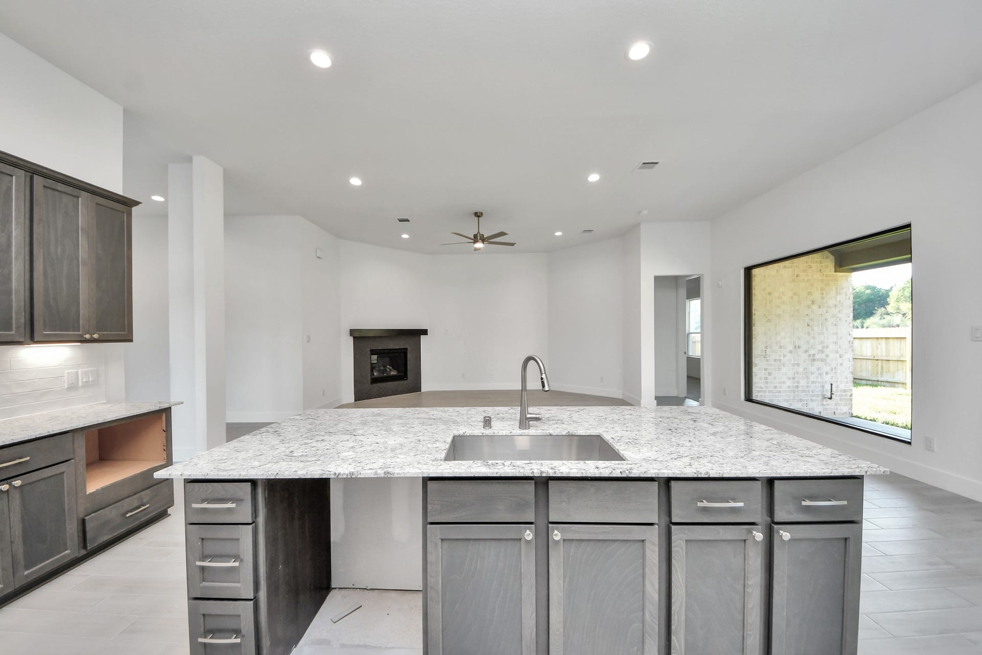 This generously spacious kitchen is a dream realized! With a massive granite island, high ceilings, soft close cabinets, granite countertops, stainless steel appliances, a sleek tile backsplash, recessed lighting, and an extended counter area, it offers both style and practicality. All this opens up to the expansive family room, creating a perfect hub for gatherings.