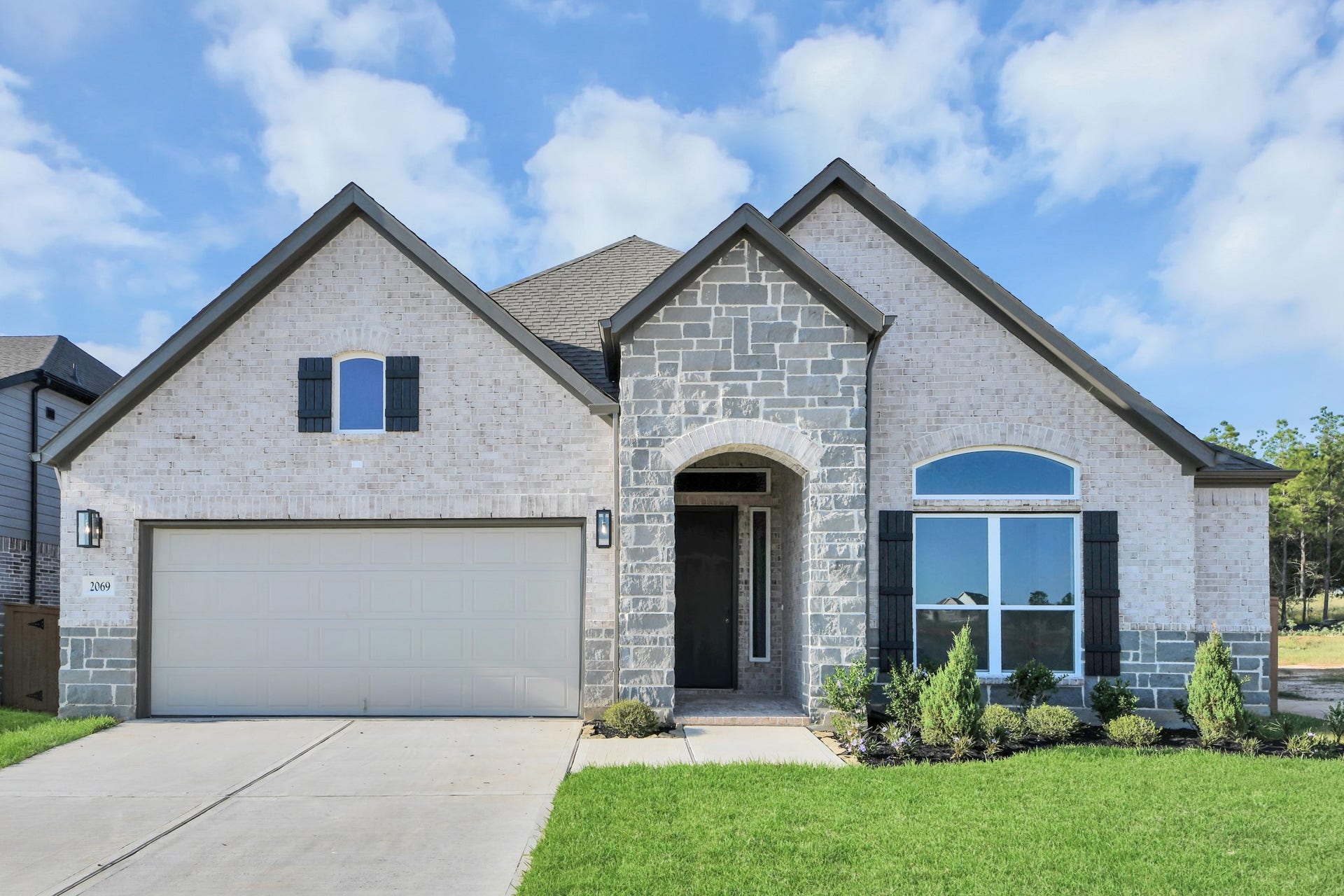 The residence features a practical 2-car garage complemented by a generous driveway, ensuring abundant space for parking needs.