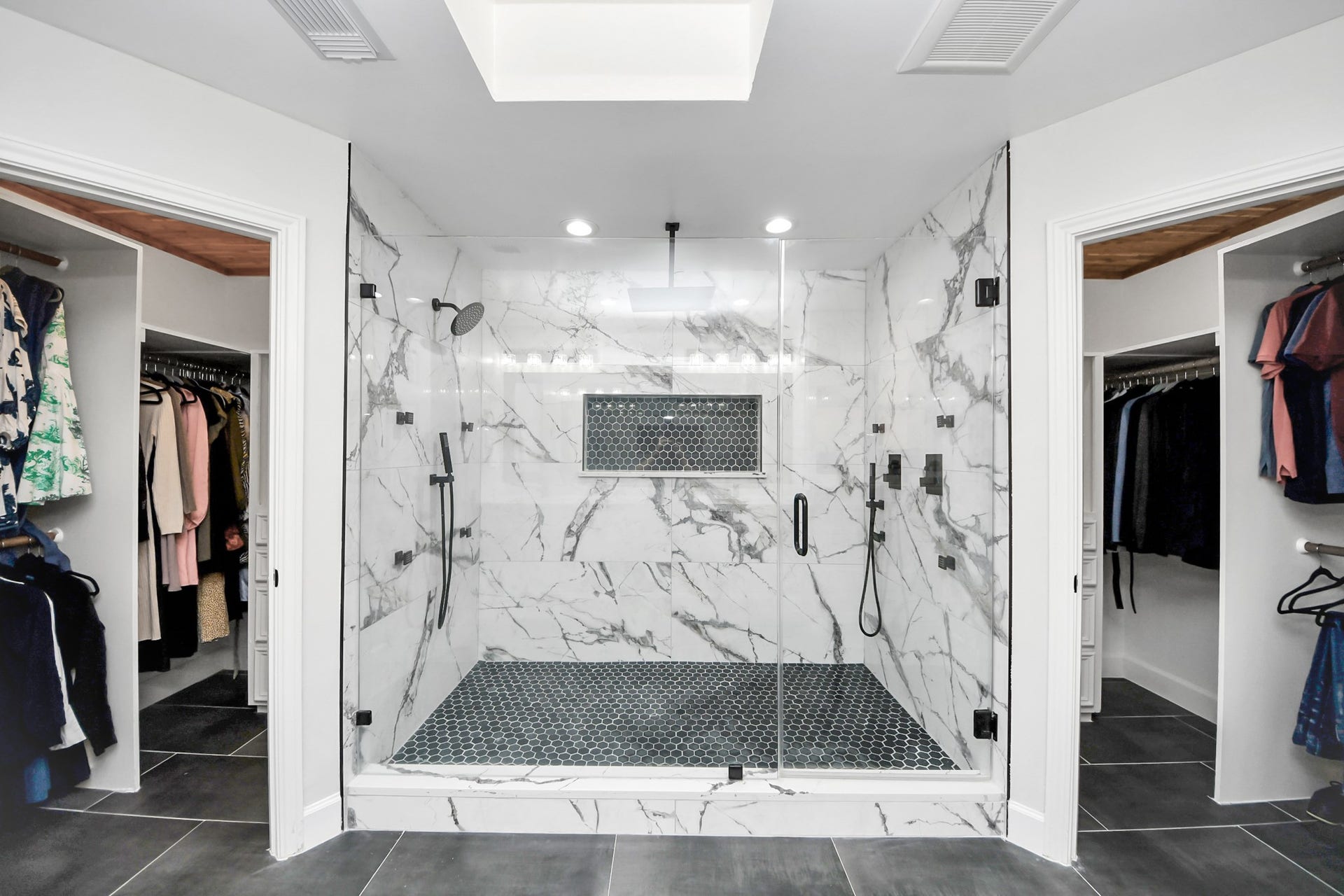 24 Hornsilver Place, The Woodlands, TX 77381 Luxurious marble shower with dual rain shower heads and modern fixtures, flanked by spacious walk-in closets.