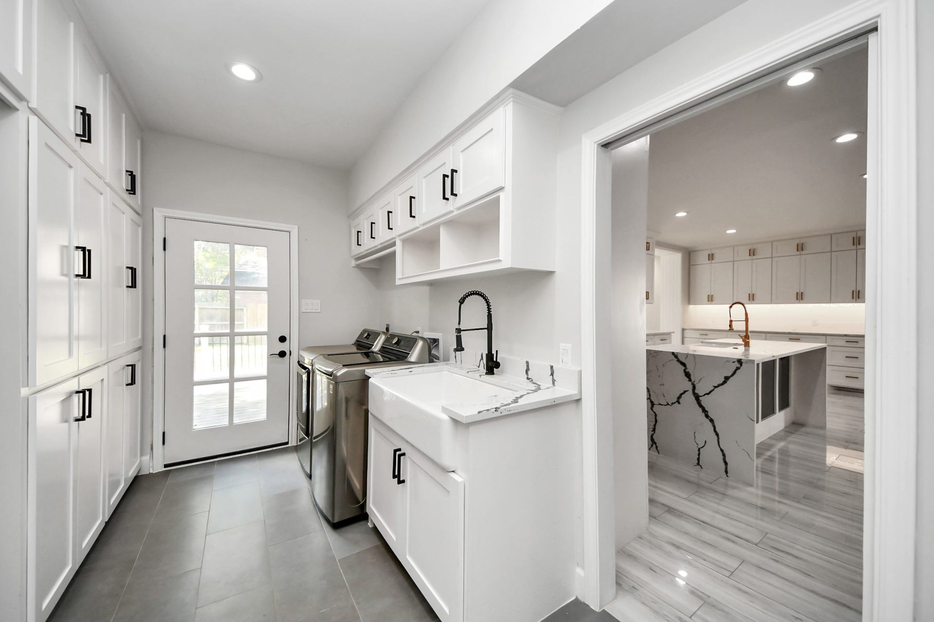 24 Hornsilver Place, The Woodlands, TX 77381 Laundry/utility room with abundant storage, full-size washer and dryer, and a farmhouse sink.