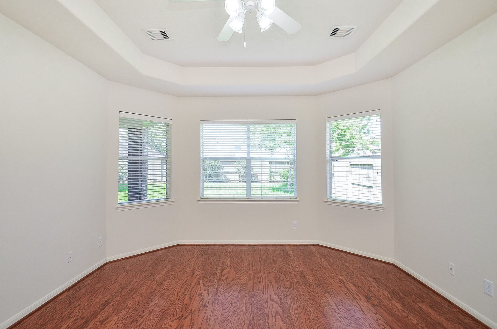 4746 Autumn Orchard Lane, Katy, TX 77494 Experience the elegance of primary room, featuring a grand entrance with a stunning arched window and tray ceiling, welcoming you with warmth and style.
