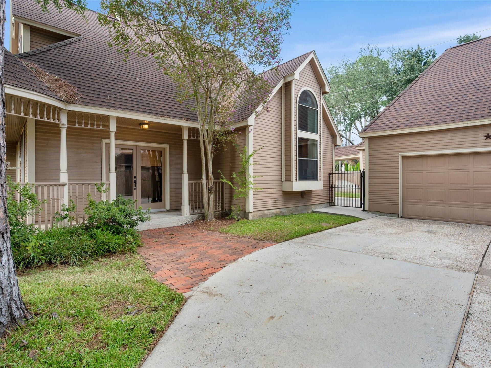 18006 Memorial Estates Drive, Spring, TX 77379 From the front, you can see the brick walk, the covered porch, and the driveway back to the detached two car garage.