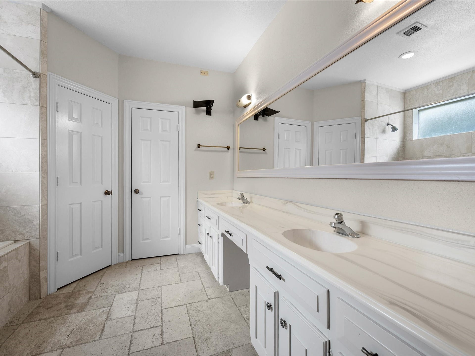 18006 Memorial Estates Drive, Spring, TX 77379 The primary bath has a long vanity with double sinks and tile floors.