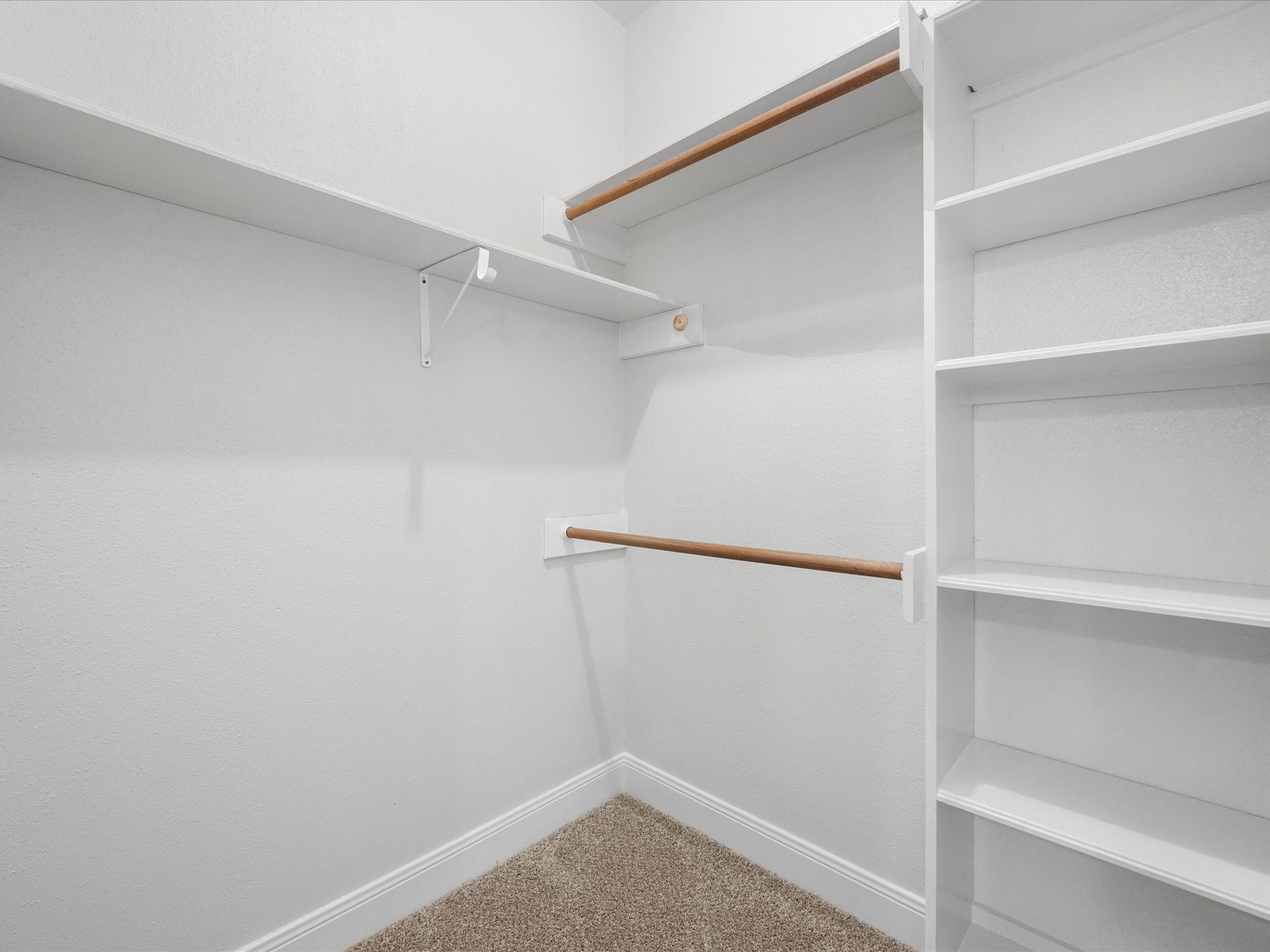 18006 Memorial Estates Drive, Spring, TX 77379 This is one of two primary closets, with hanging rods and built-in shelves.