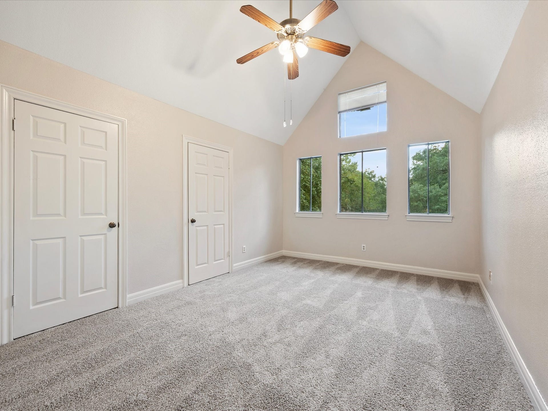 18006 Memorial Estates Drive, Spring, TX 77379 This upstairs bedroom has a vaulted ceiling with windows stacked up high.