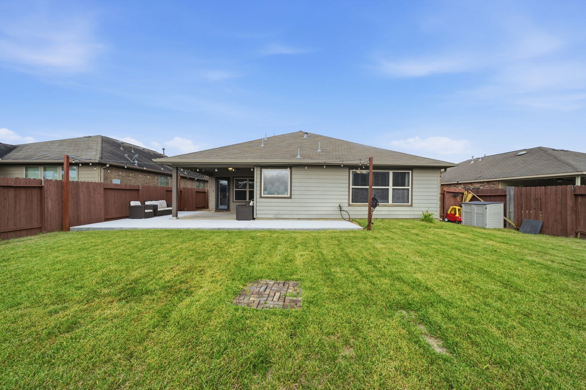 336 Country Crossing Circle, Magnolia, TX 77354 Spacious backyard with a well-maintained lawn, a large patio perfect for entertaining, and privacy fencing for a serene outdoor experience.
