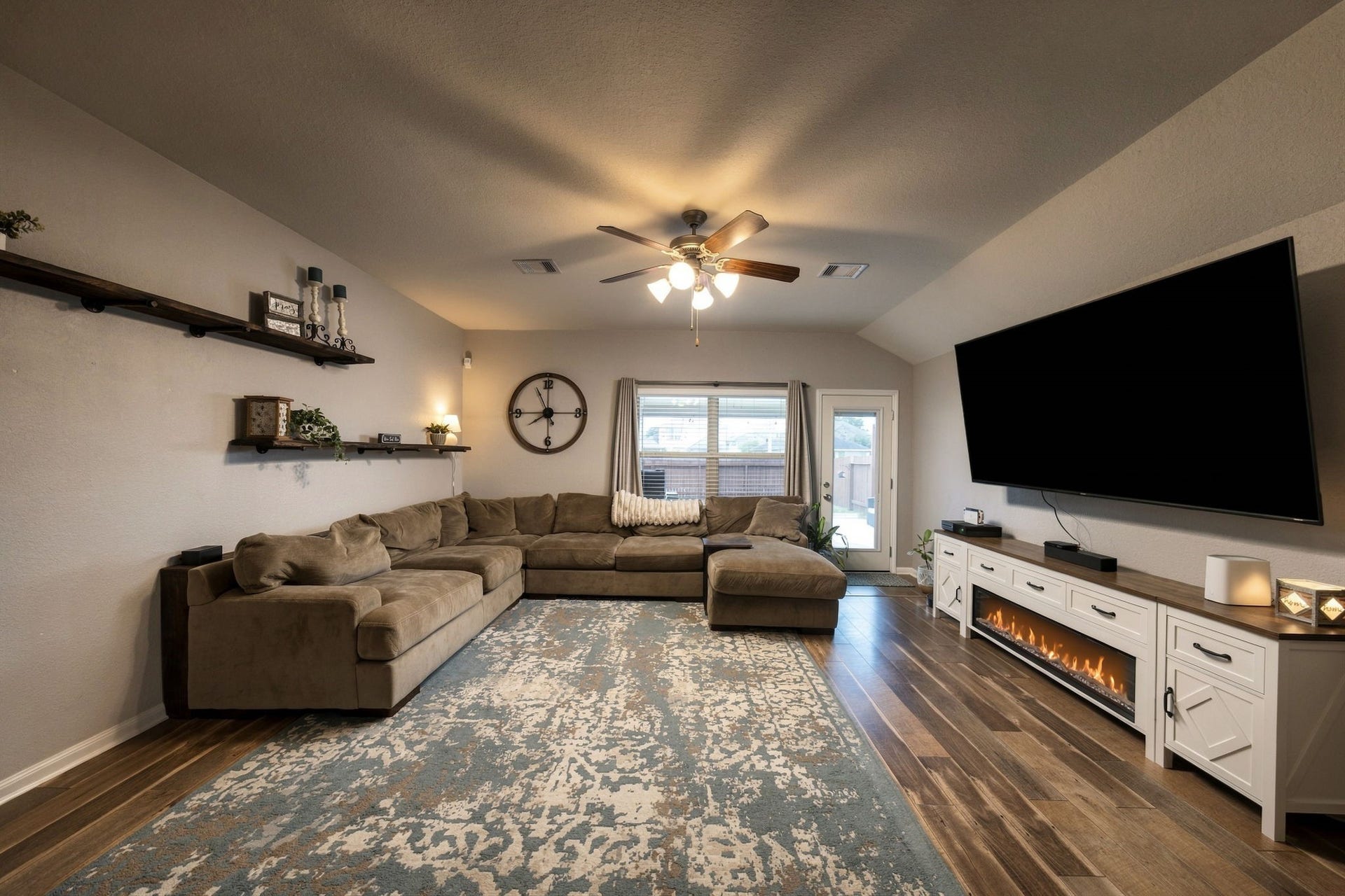 336 Country Crossing Circle, Magnolia, TX 77354 Spacious living room with elegant LVP flooring, a modern ceiling fan, and ample natural light through the rear windows.
