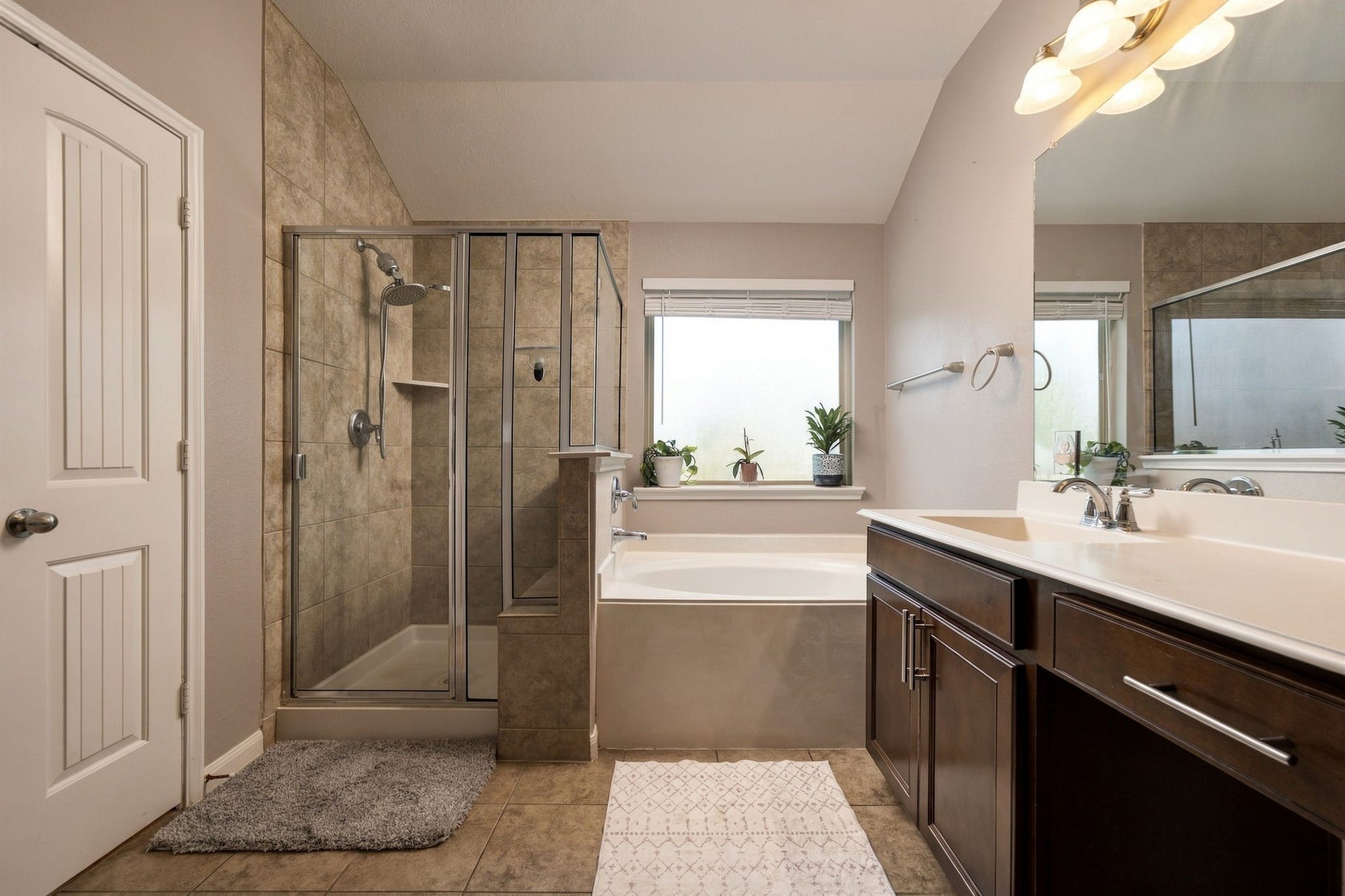 336 Country Crossing Circle, Magnolia, TX 77354 Spacious bathroom featuring a glass-enclosed shower, a luxurious soaking tub, and a dual-sink vanity with ample storage.