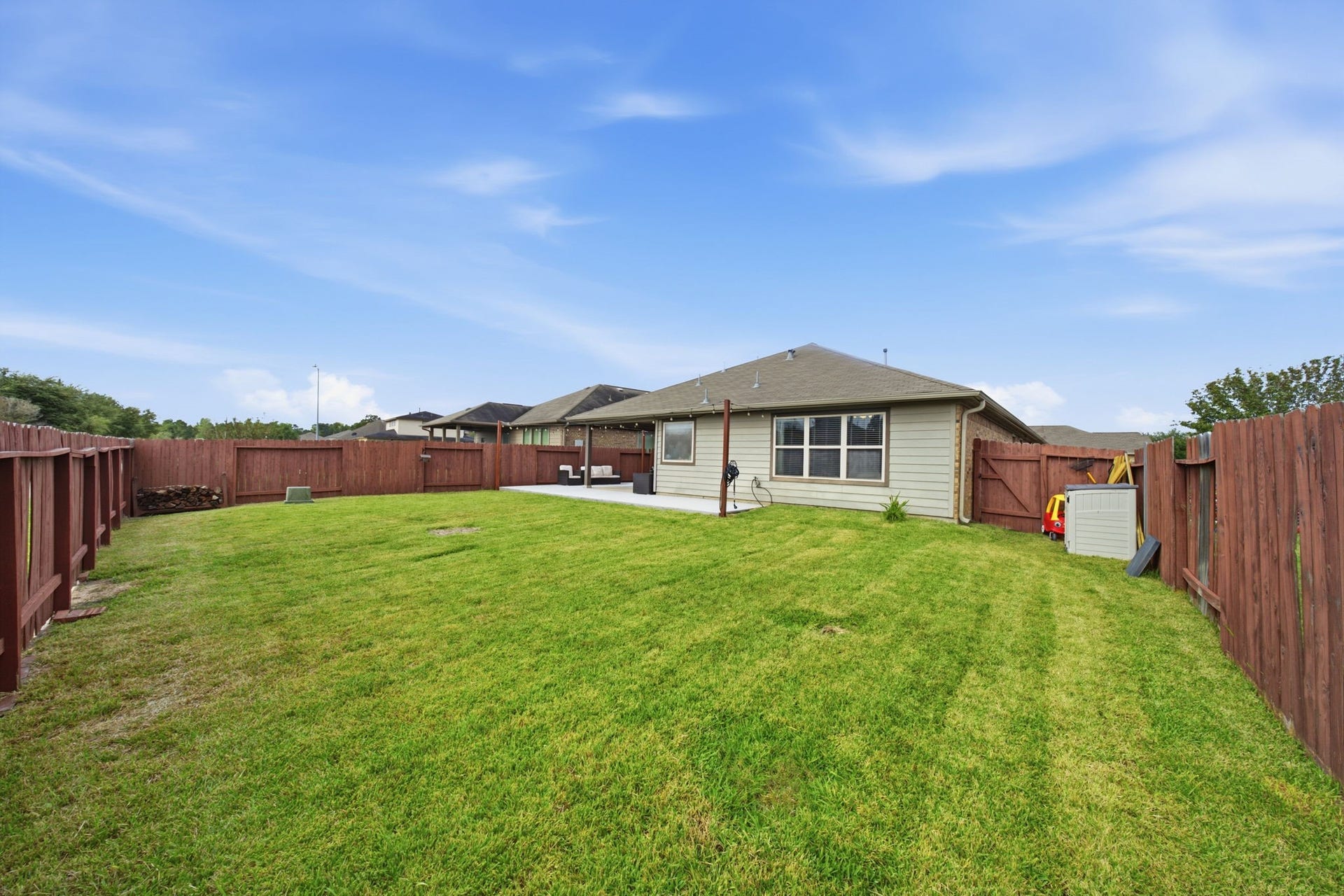 336 Country Crossing Circle, Magnolia, TX 77354 Spacious backyard with a well-maintained lawn, perfect for outdoor activities and entertaining, enclosed by a sturdy wooden fence for privacy.
