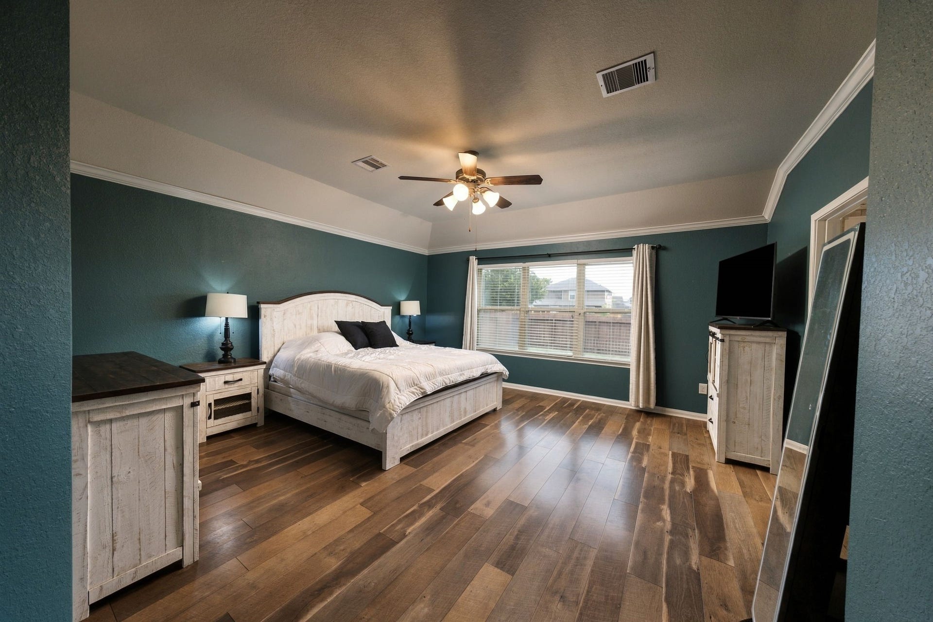 336 Country Crossing Circle, Magnolia, TX 77354 Spacious bedroom featuring rich wood flooring and abundant natural light from large windows.