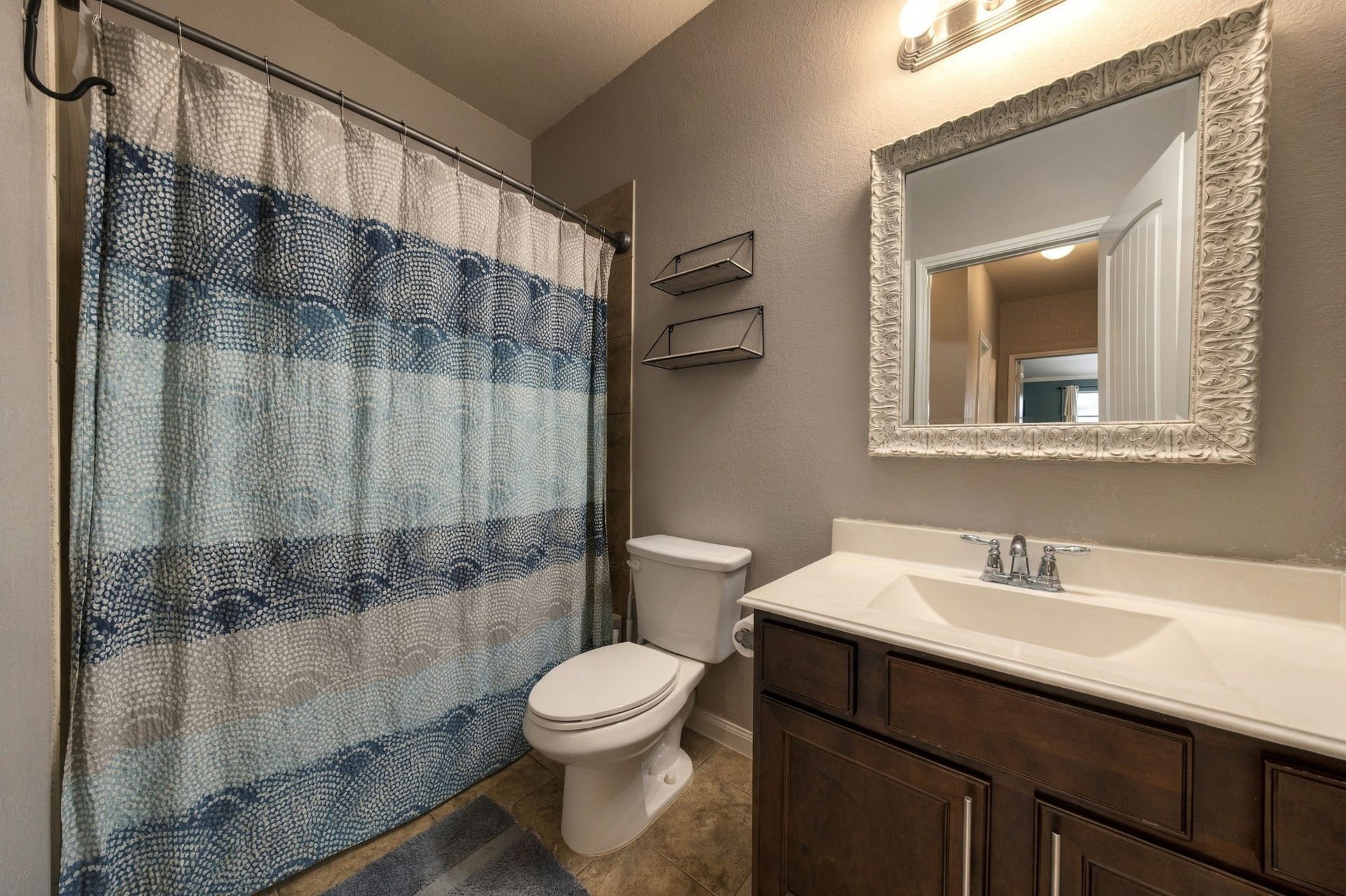 336 Country Crossing Circle, Magnolia, TX 77354 Charming bathroom featuring elegant vanity with a large ornate mirror, and contemporary lighting.