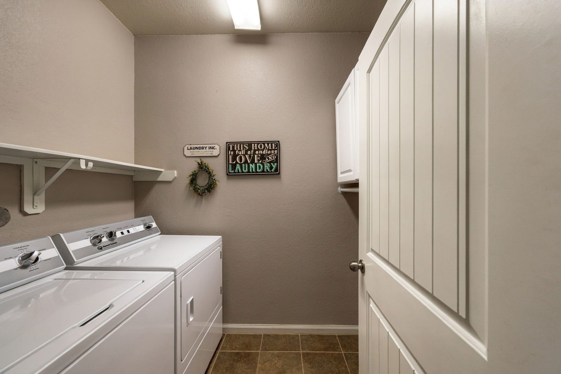 336 Country Crossing Circle, Magnolia, TX 77354 Bright and functional laundry room featuring modern appliances, ample shelving, and stylish decor.