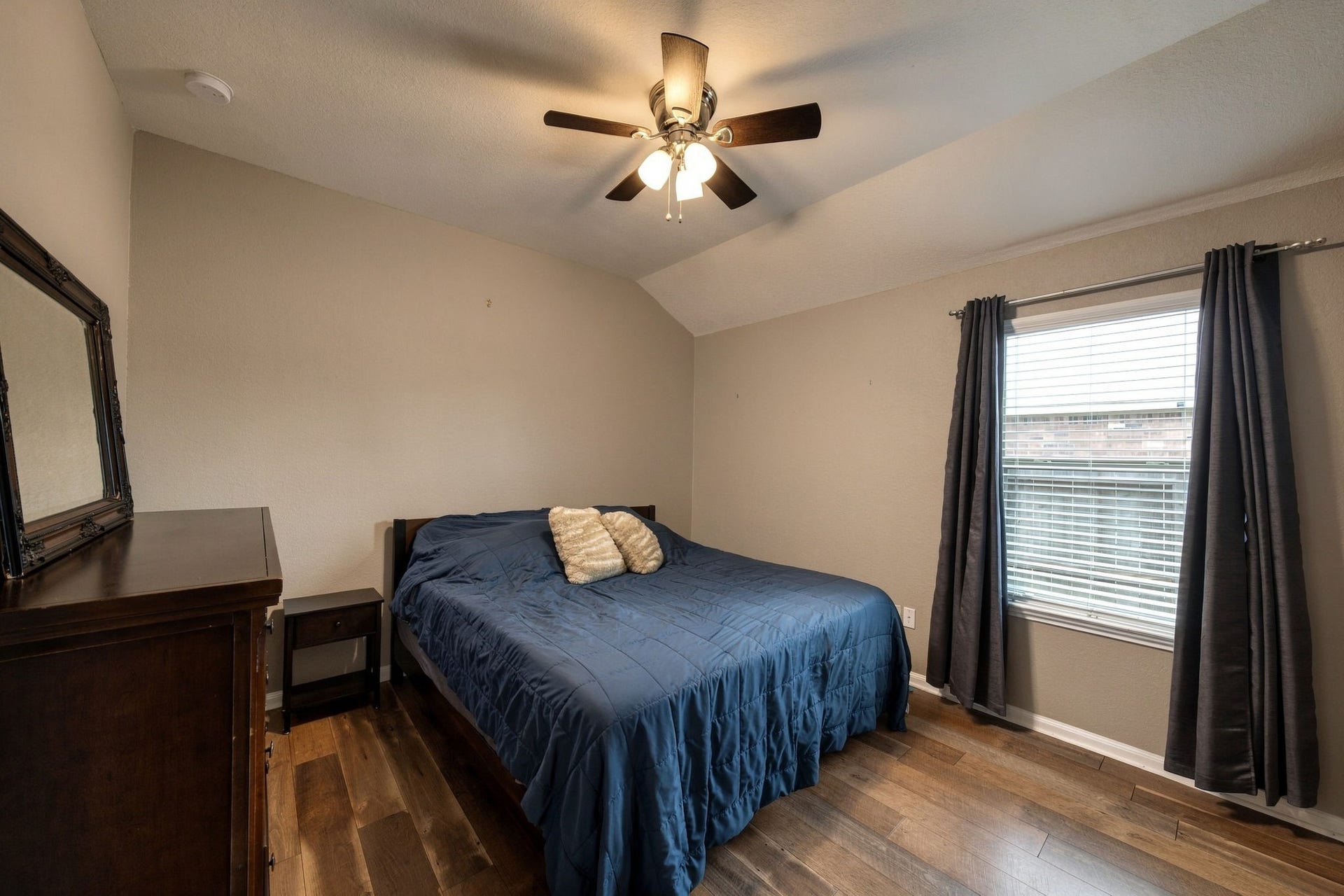 336 Country Crossing Circle, Magnolia, TX 77354 Cozy bedroom featuring warm wooden floors, a ceiling fan for comfort, and ample natural light through a large window.