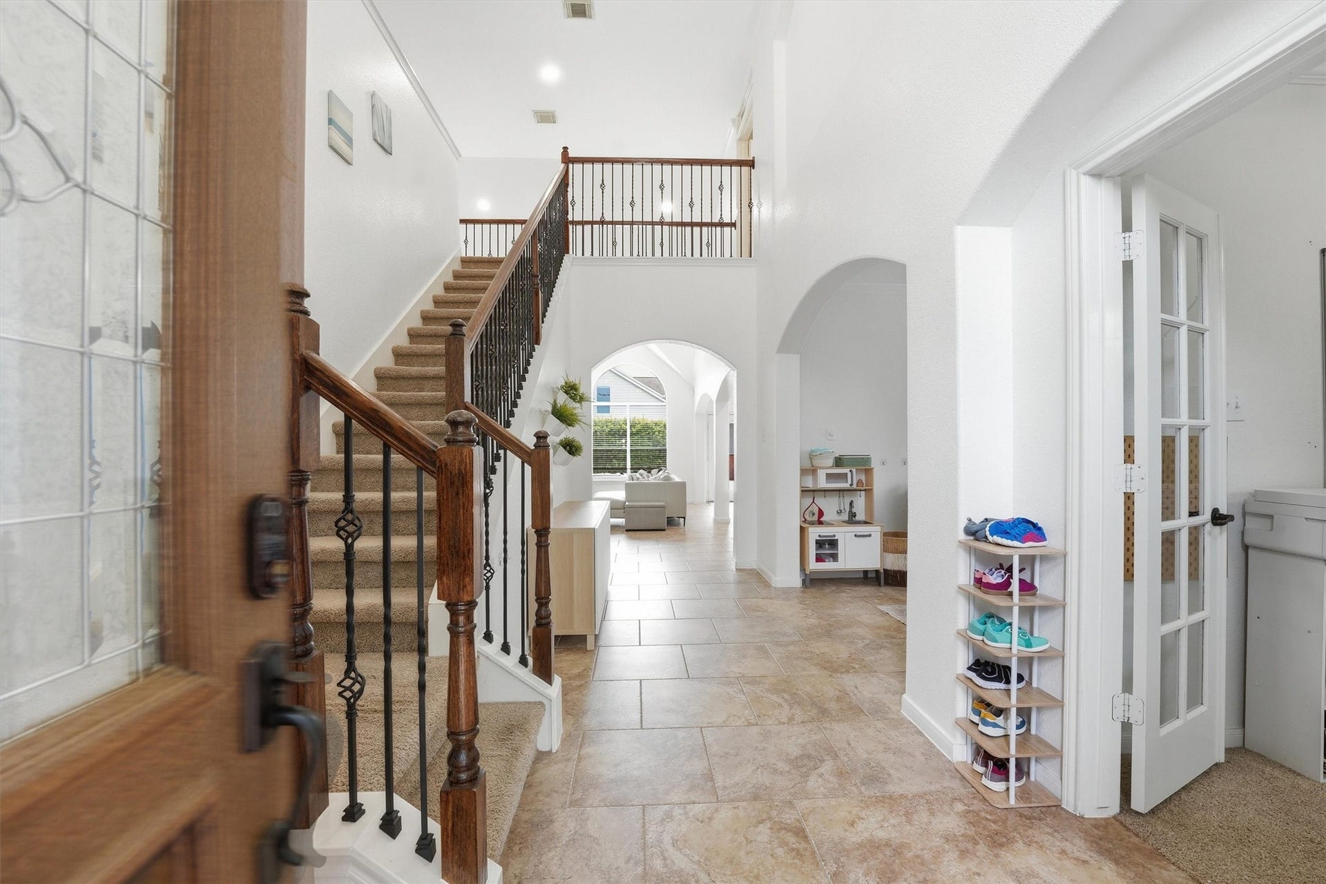 This is a two-story brick home with a two-car garage and well-maintained landscaping. The driveway is spacious, and the front yard features mature trees and shrubs, adding charm and privacy.