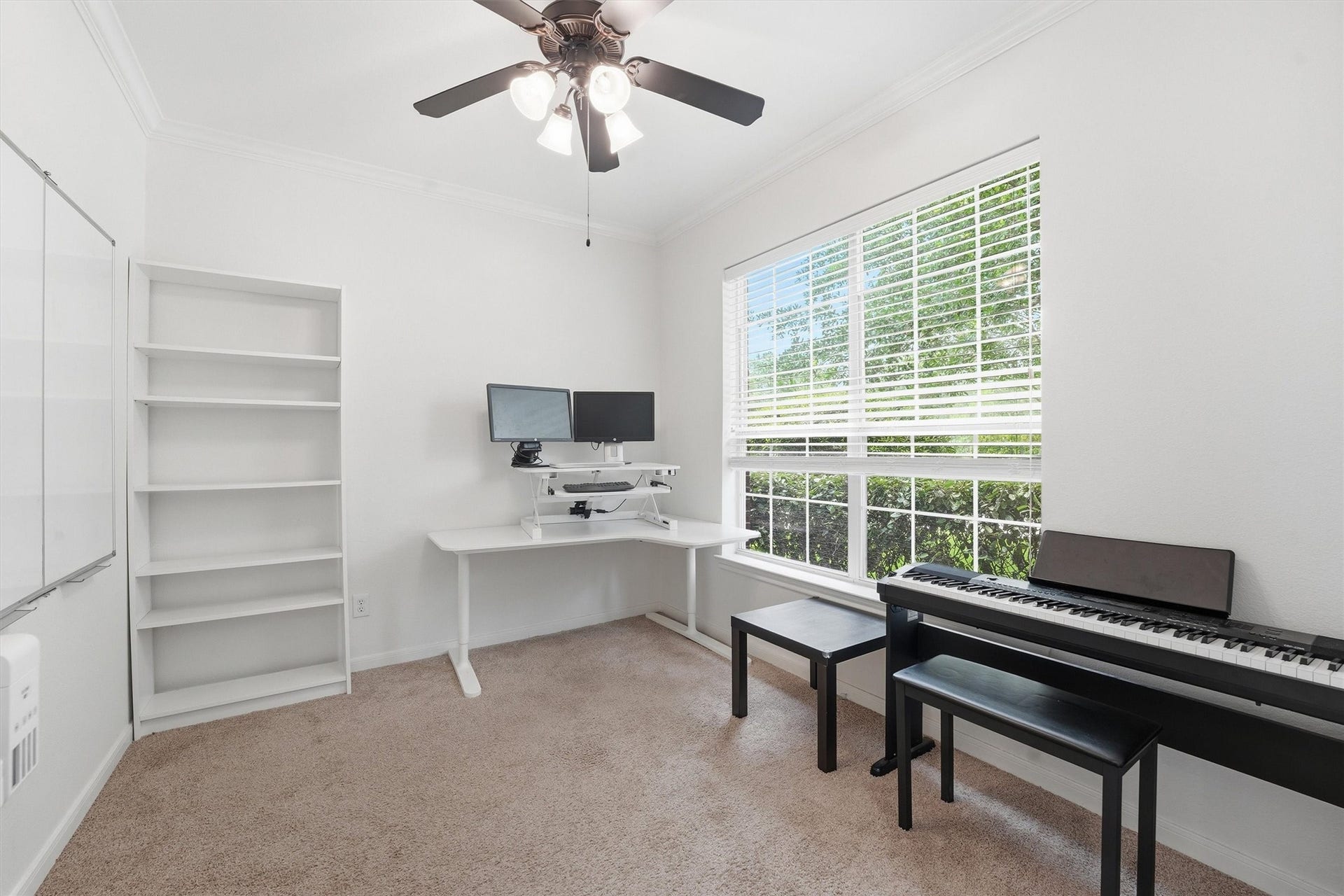 This photo showcases a bright, welcoming entryway with a staircase featuring dark wood and iron railings. The space has tiled flooring, high ceilings, and leads to a comfortable, sunlit living area. Wall decor and plants add a touch of warmth.