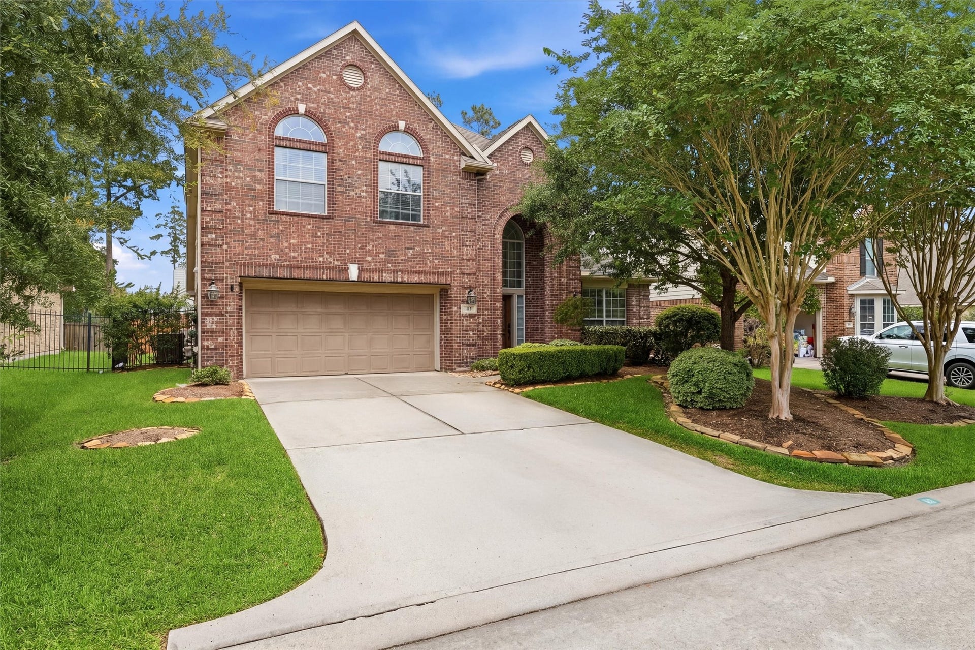 This photo showcases a charming brick home with a spacious backyard, featuring a well-maintained pool surrounded by a stone patio. The lush green lawn and privacy fence create a serene outdoor space ideal for relaxation and entertaining.