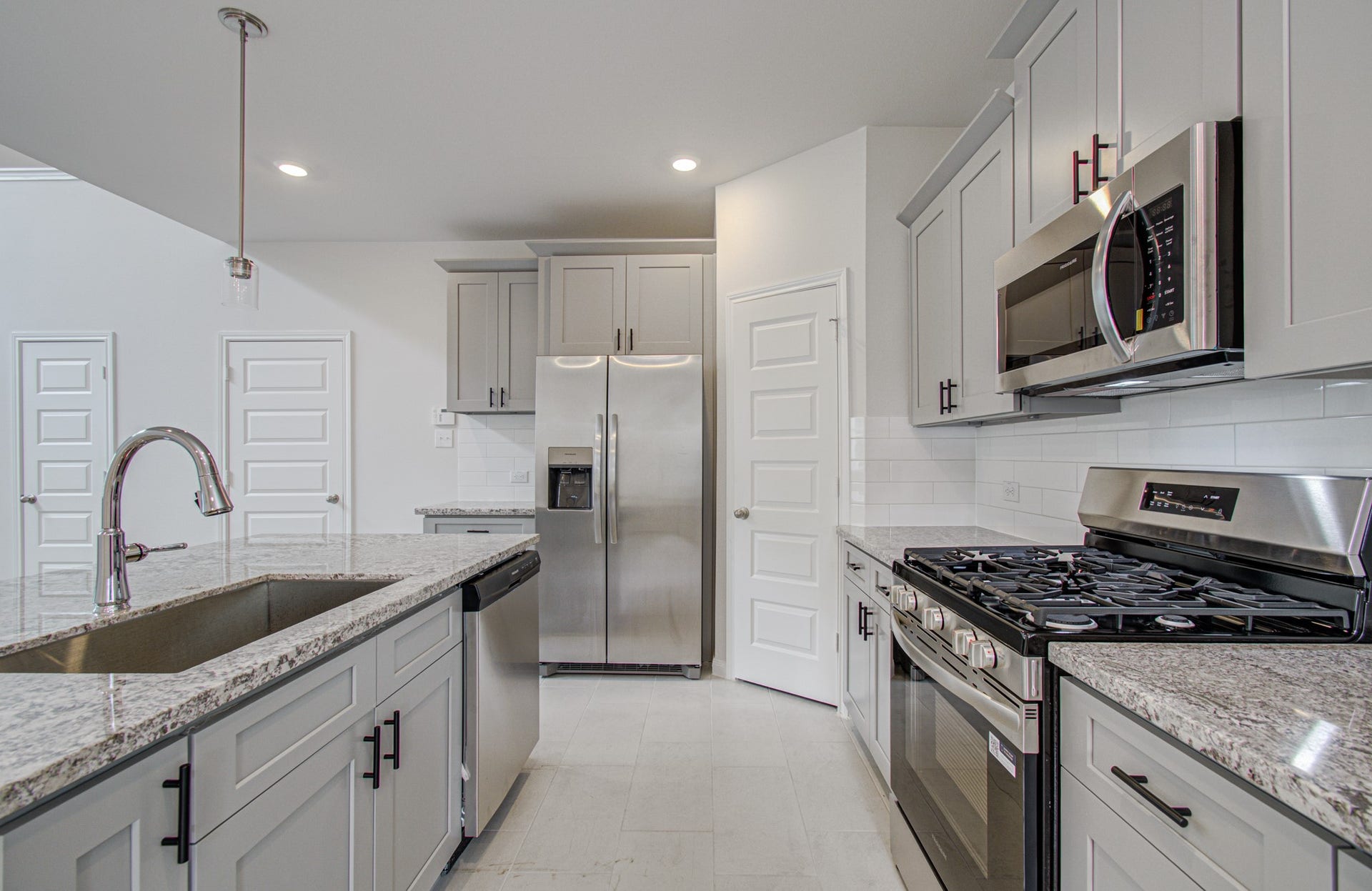 14210 Aston Pine Drive, Houston, TX 77032 Modern kitchen featuring sleek stainless steel appliances, granite countertops, and ample cabinetry for storage. Please Note this is a different home/floorplan in the community.