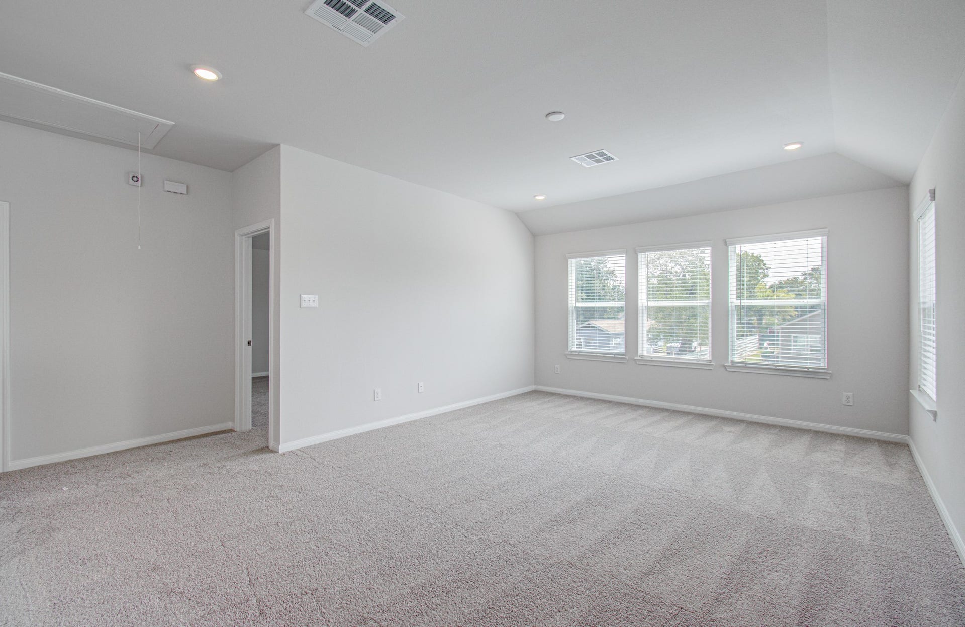 14210 Aston Pine Drive, Houston, TX 77032 Spacious, light-filled room with large windows, plush carpeting, and a neutral color palette, perfect for versatile living. Please Note this is a different home/floorplan in the community.