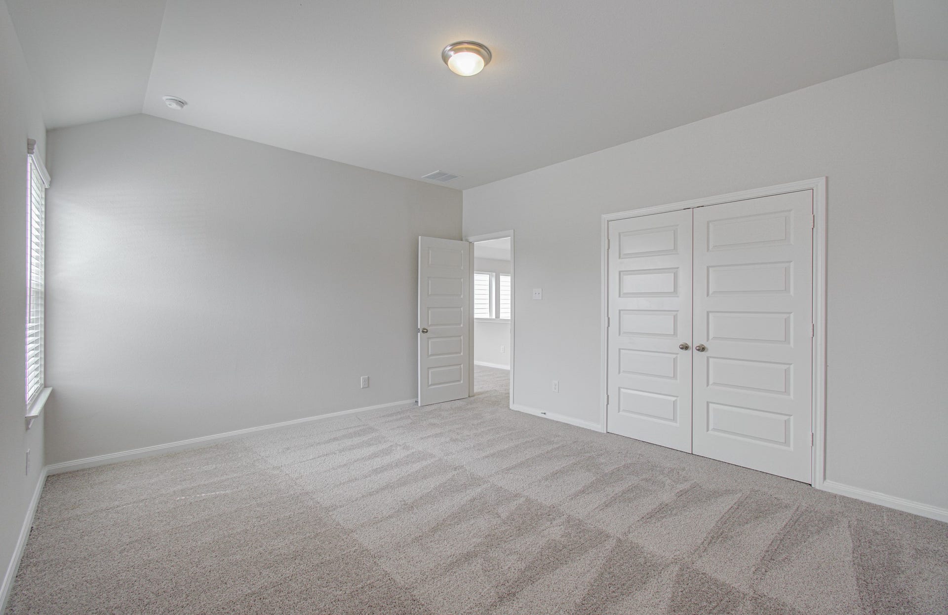 14210 Aston Pine Drive, Houston, TX 77032 Spacious third bedroom with plush carpeting, ample natural light from large windows, and dual-door closet for convenient storage. Please Note this is a different home/floorplan in the community.