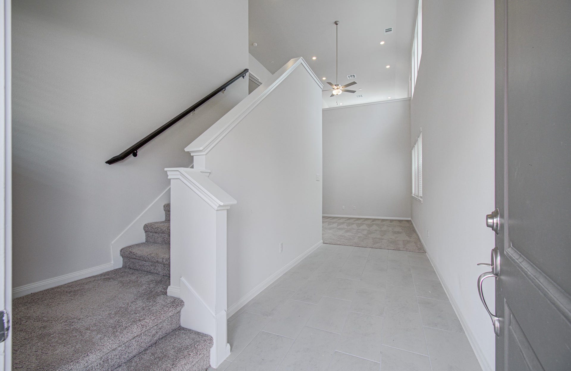 14210 Aston Pine Drive, Houston, TX 77032 Bright entryway with high ceilings, leading to a cozy carpeted staircase and an open living area. Please Note this is a different home/floorplan in the community.
