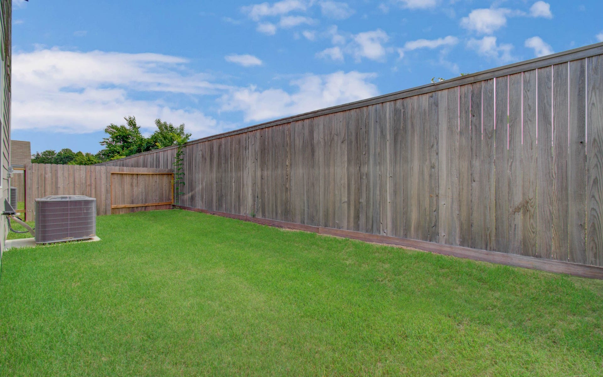 14210 Aston Pine Drive, Houston, TX 77032 Spacious backyard with lush green grass and a privacy fence, perfect for outdoor activities and relaxation. Please Note this is a different home/floorplan in the community.
