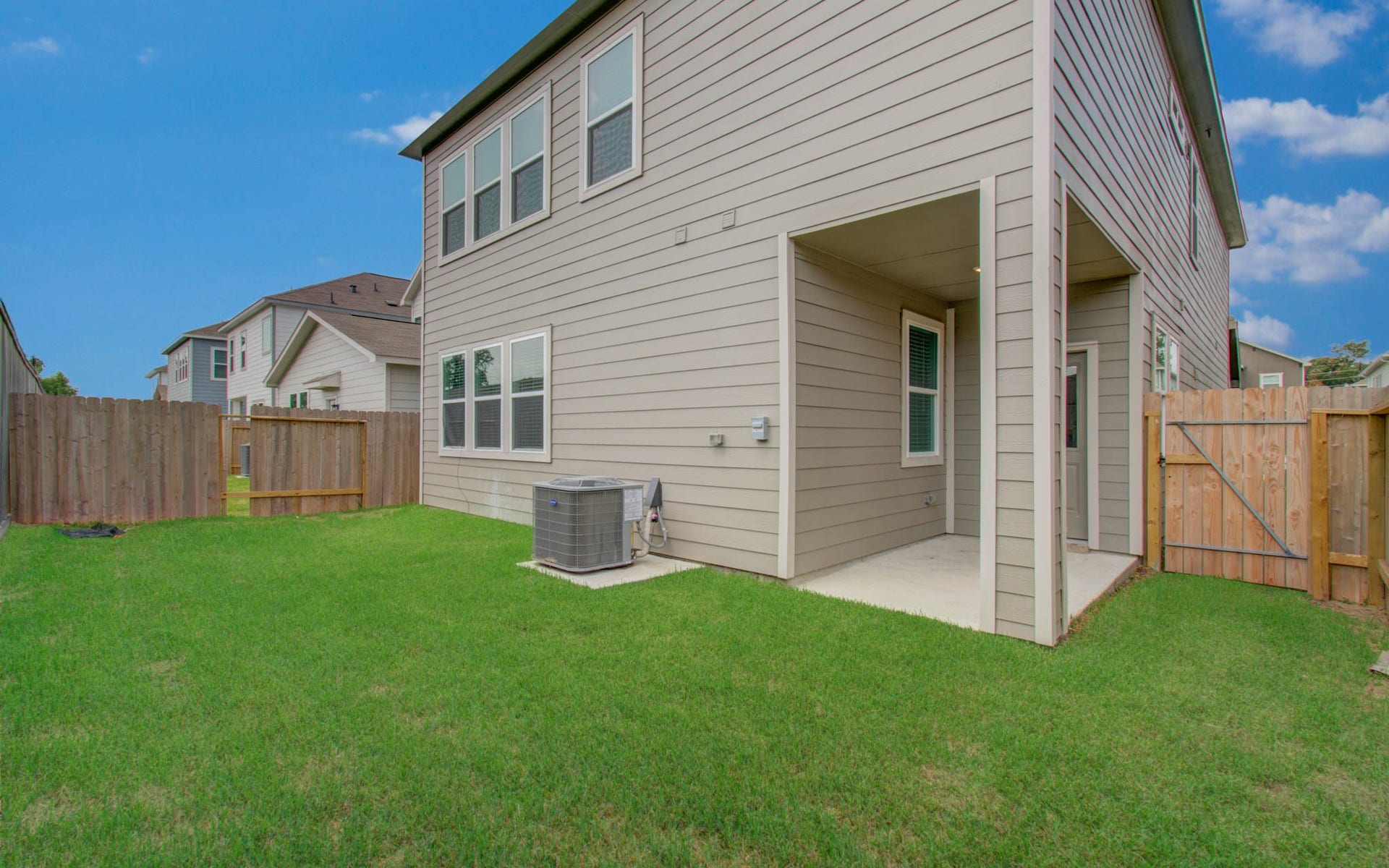 14210 Aston Pine Drive, Houston, TX 77032 Spacious backyard featuring a covered patio, perfect for outdoor relaxation, with a well-maintained lawn and privacy fence. Please Note this is a different home/floorplan in the community.