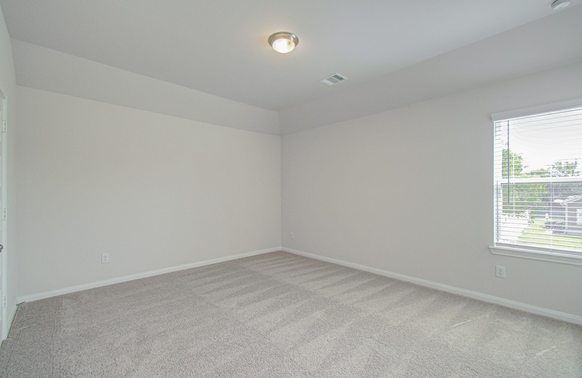 14210 Aston Pine Drive, Houston, TX 77032 Spacious and bright third bedroom with soft carpet and a large window providing ample natural light. Please Note this is a different home/floorplan in the community.