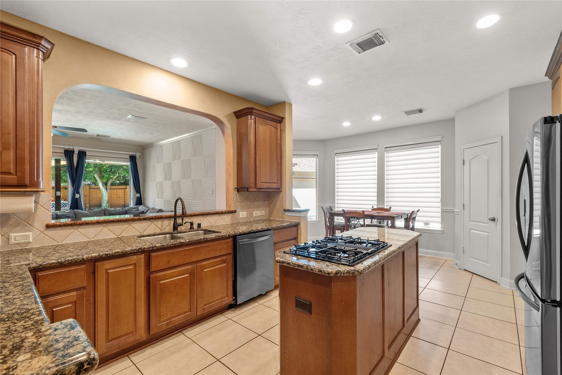11 Saint Thomas Court, Houston, TX 77070 An inviting kitchen with beautiful cabinetry, an island with cooktop and an easy connection to the sunny breakfast area offers plenty of space for cooking, conversation and casual gatherings.