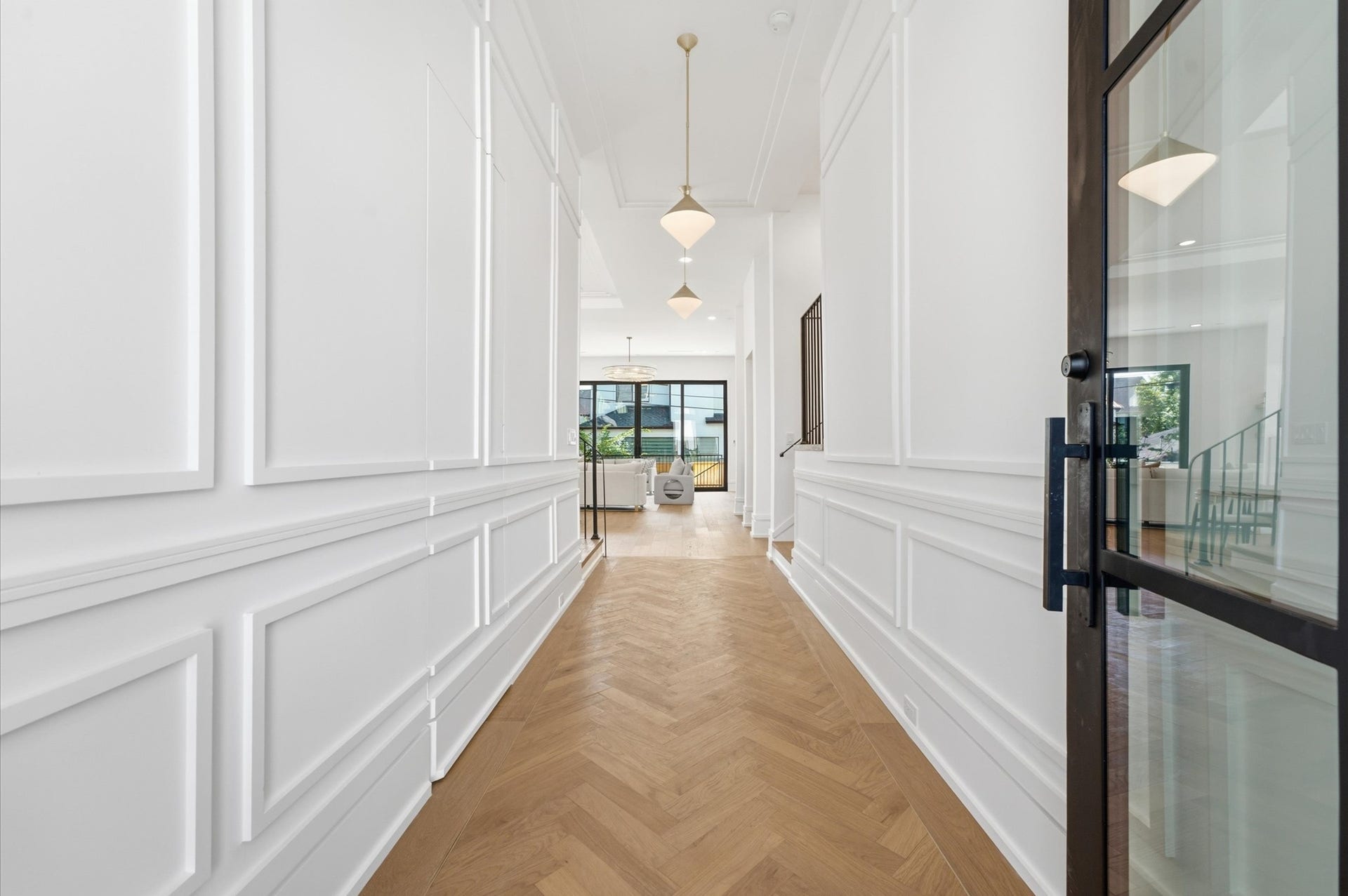 4313 Lula Street, Bellaire, TX 77401 Bright entry hallway featuring detailed wall molding and warm wood flooring.